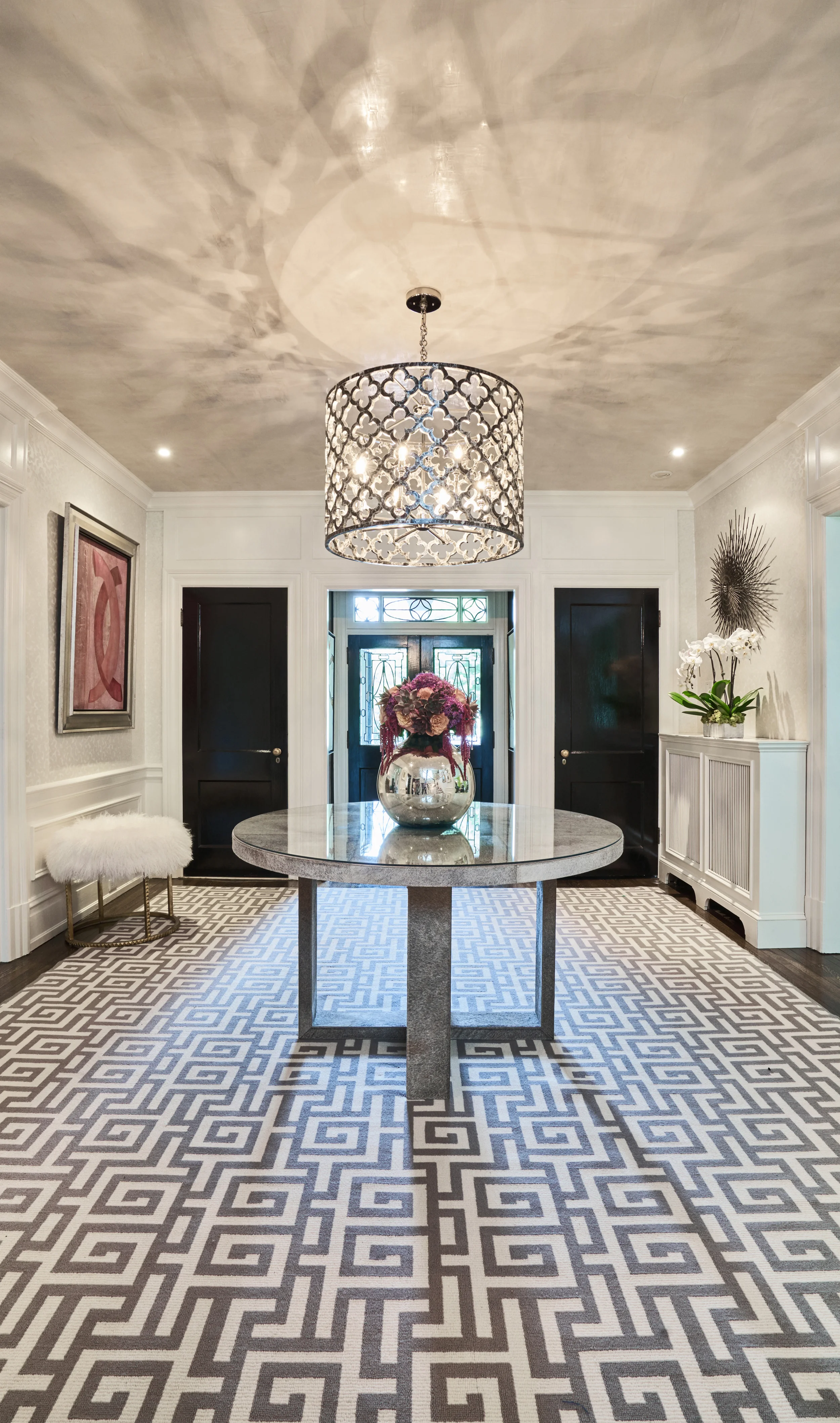Graphic rug gives foyer a modern take against a traditional background.
