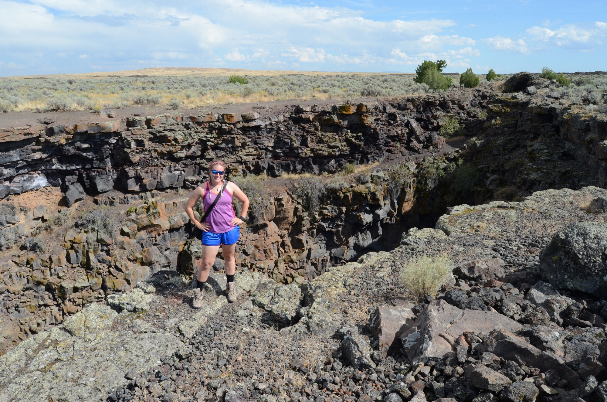 Nicki Button conducting fieldwork at Kings Bowl, an explosive volcanic vent that once ejected many large blocks in Craters of the Moon National Monument and Preserve. Button looked at the block distribution around the vent as an analog site to volcanic vents on early Mars. Photo compliments of Nicki Button.