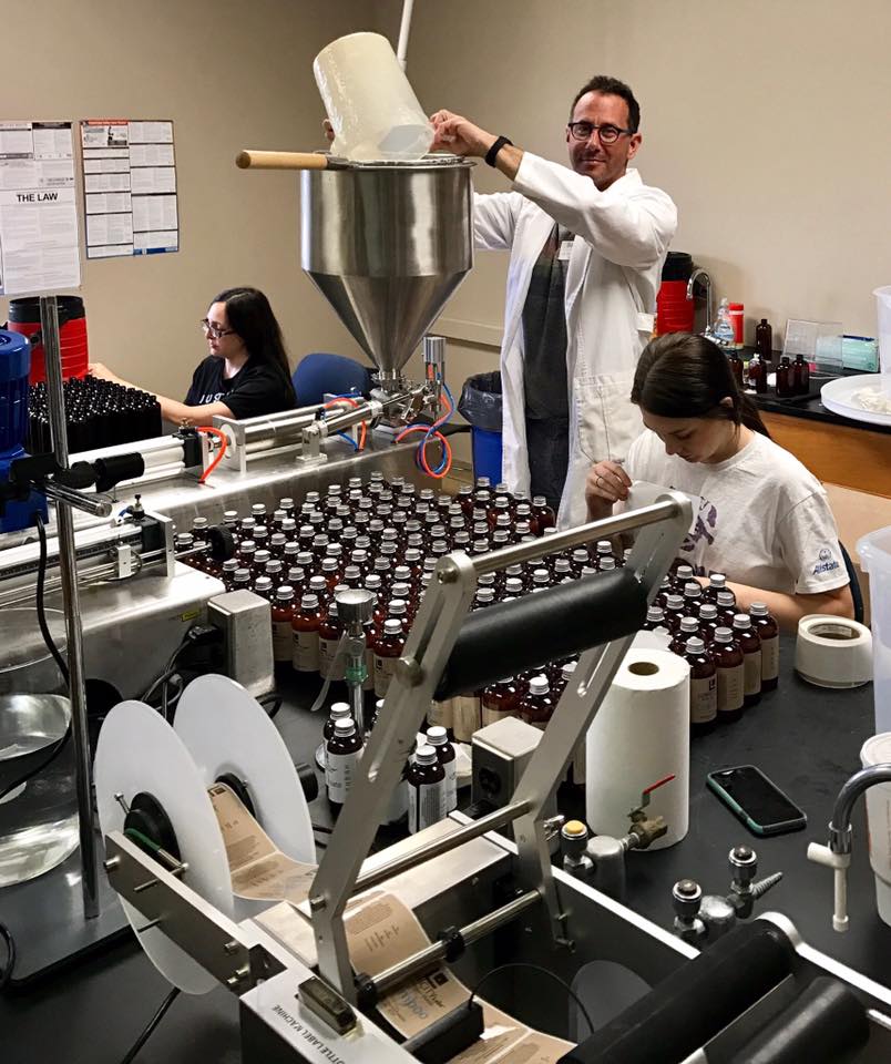 Boyce Clark bottling hair product. Photo via Lubricity Labs LLC on Facebook.