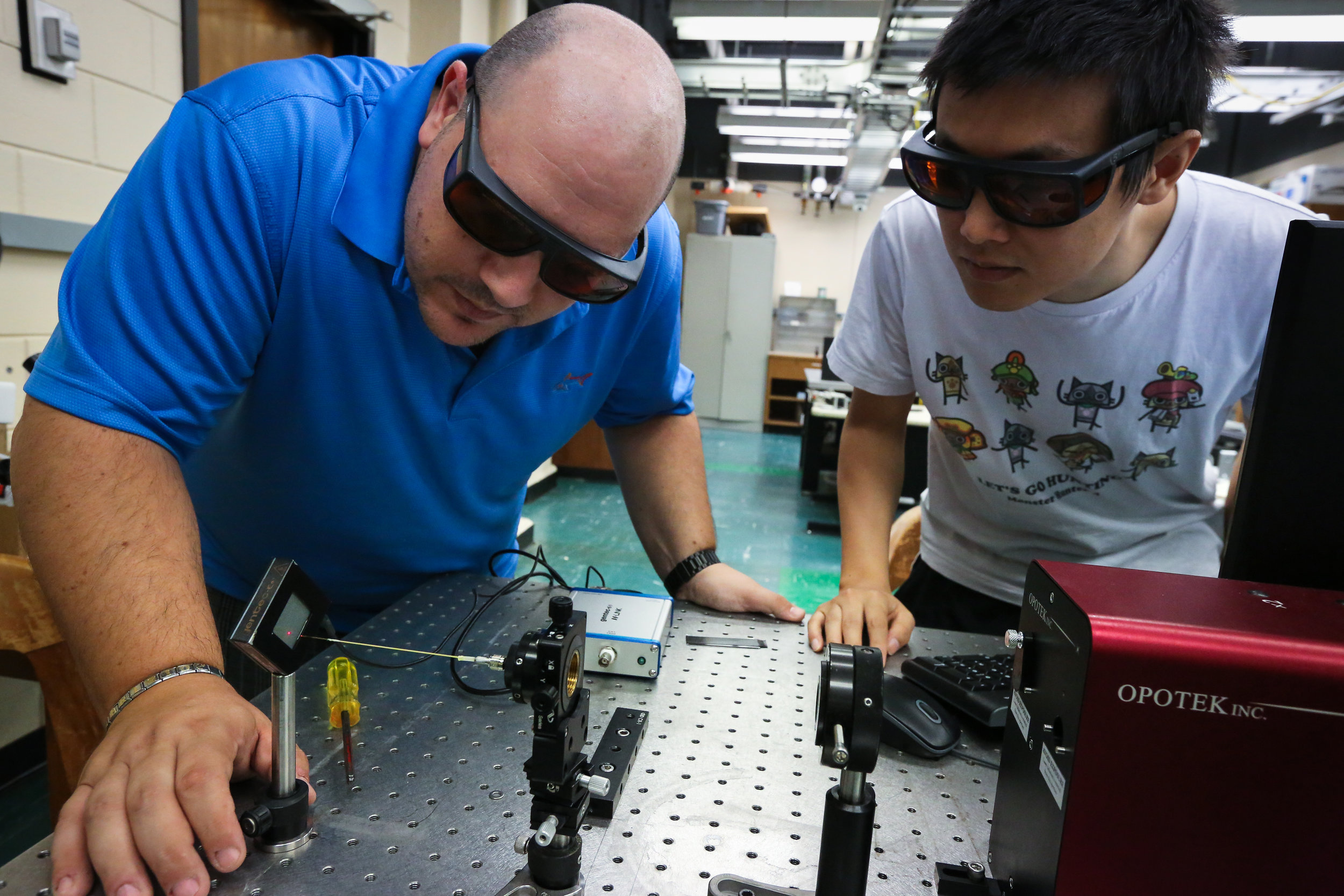 Image: LSU researchers Fabrizio Donnarumma and Fan Cao set up an infrared laser system used to remove fingermark materials from a surface for chemical analysis. Photo by Paige Jarreau.
