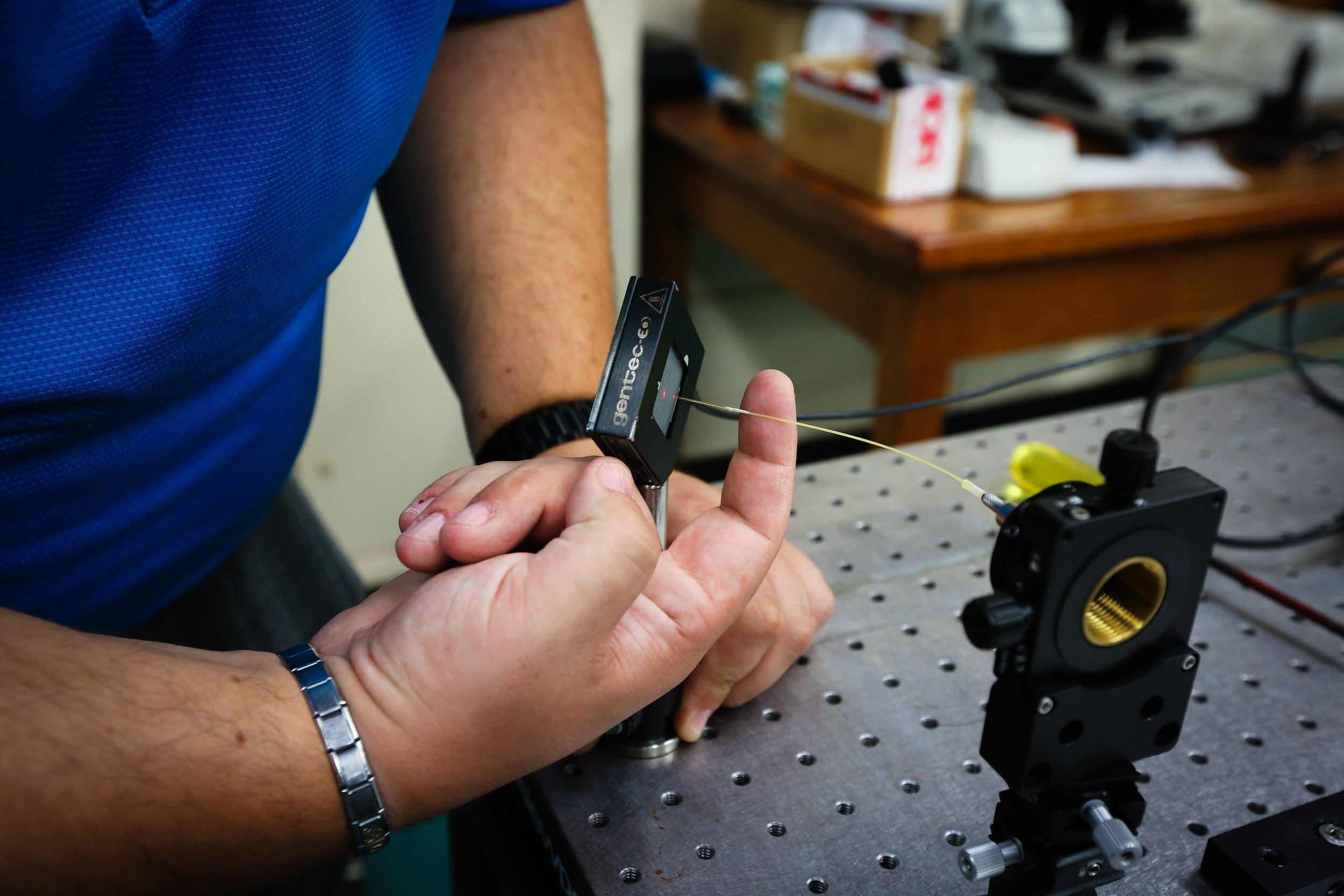 Image: Fabrizio demonstrates a flexible germanium oxide optical fiber laser attachment that could enable a portable fingermark ablation device for use by forensic experts. The laser light is visible as a red dot on the detection device. Credit: Paige Jarreau.