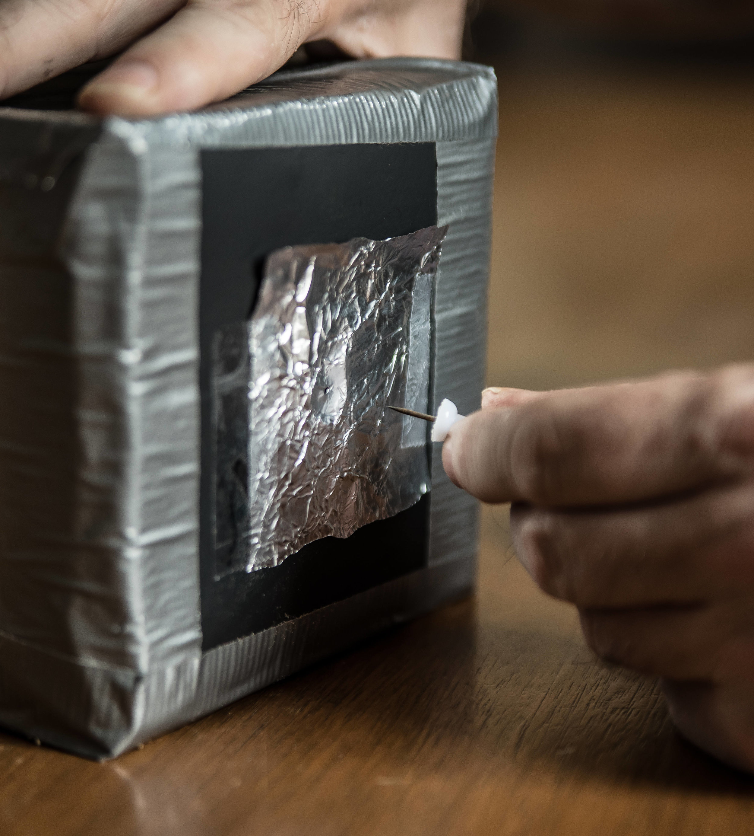 Tape foil over the hole you just made. Then, make a new small hole with a safety pin.