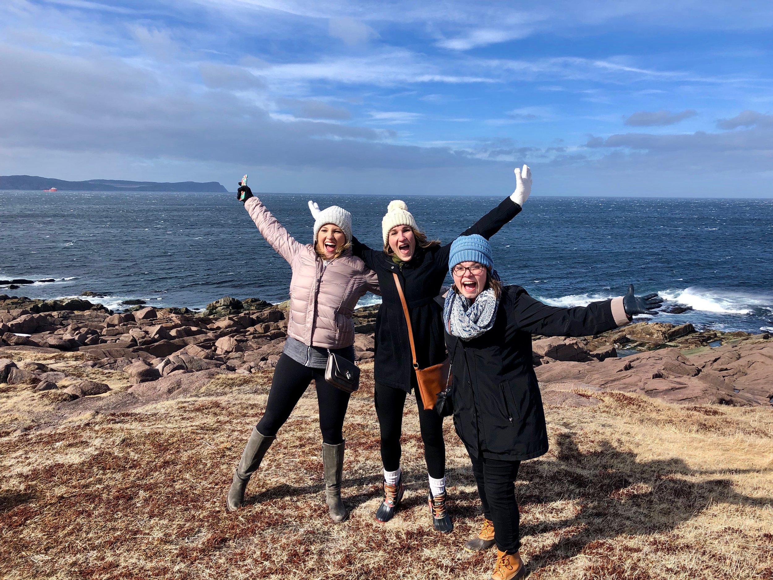 Anna (left), Alicia (center), Megan (right) being “taken” by the wind at Cape Spear. Credit: Anna Lucchesi