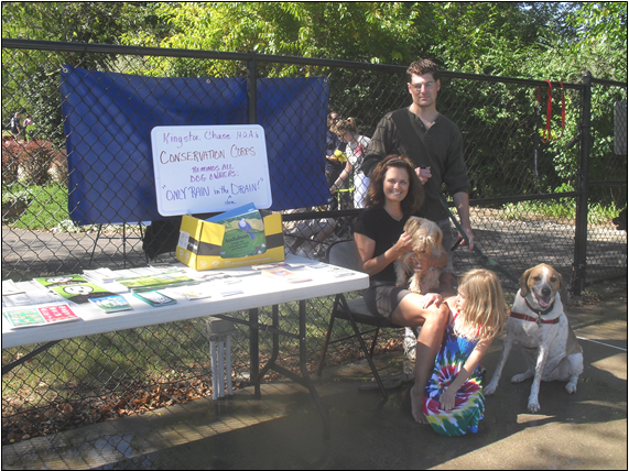 Jane Hampson, seated, sponsored a Conservation Corps booth at the 2010 Dog Day at the Pool.