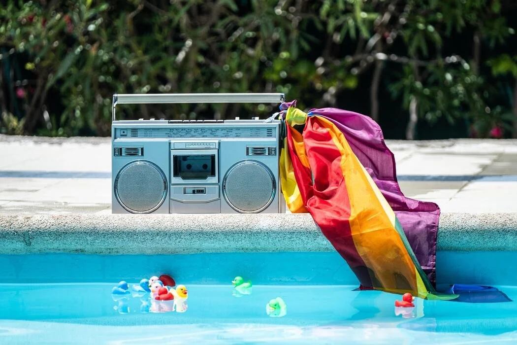 group-of-friends-sunbathing-in-the-pool-with-old-record-player-lgtbi-movement-free-photo.jpg