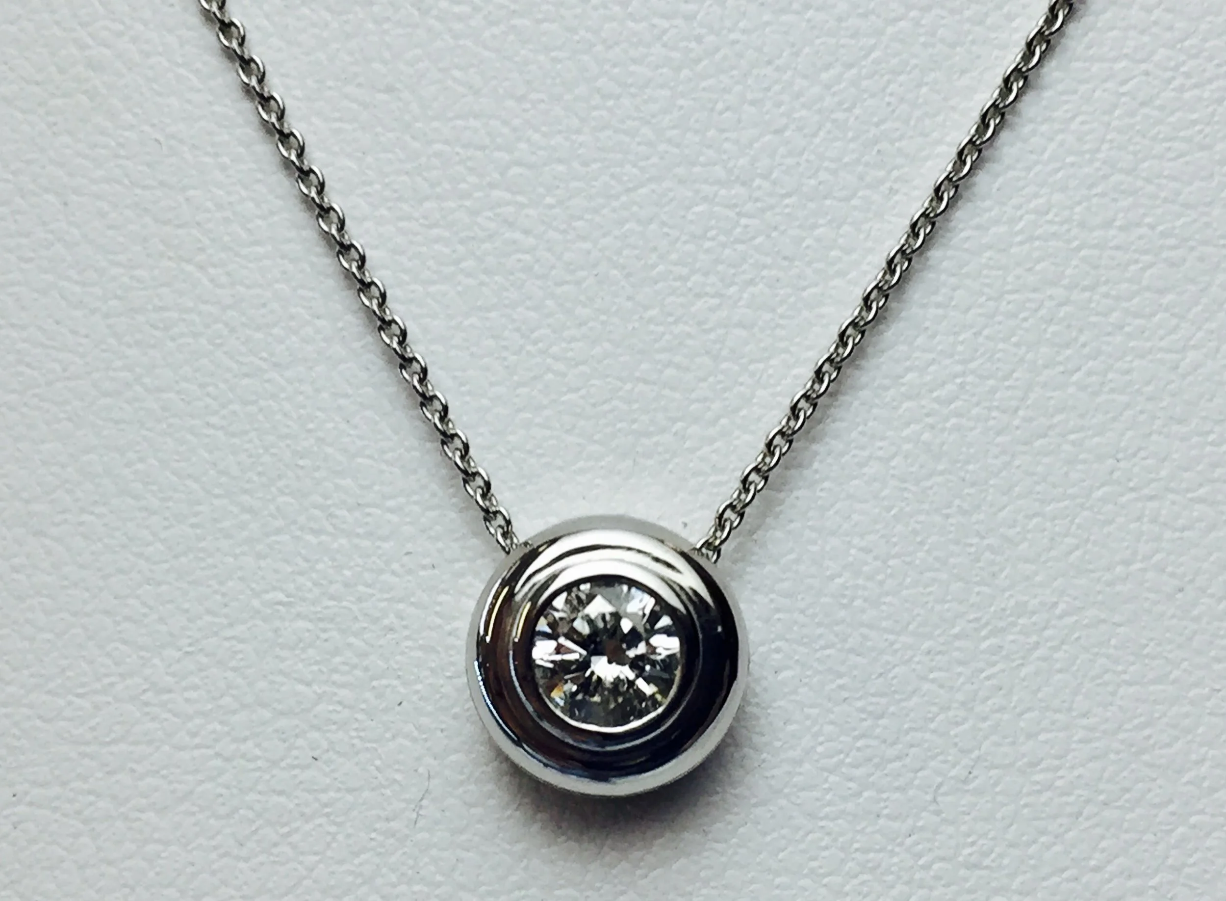 We can make a smaller diamond or colored stone into a larger looking pendant that slides on the chain.