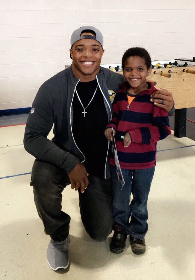 CJ Ham posing with a child from the Boys & Girls Club after signing an autograph.