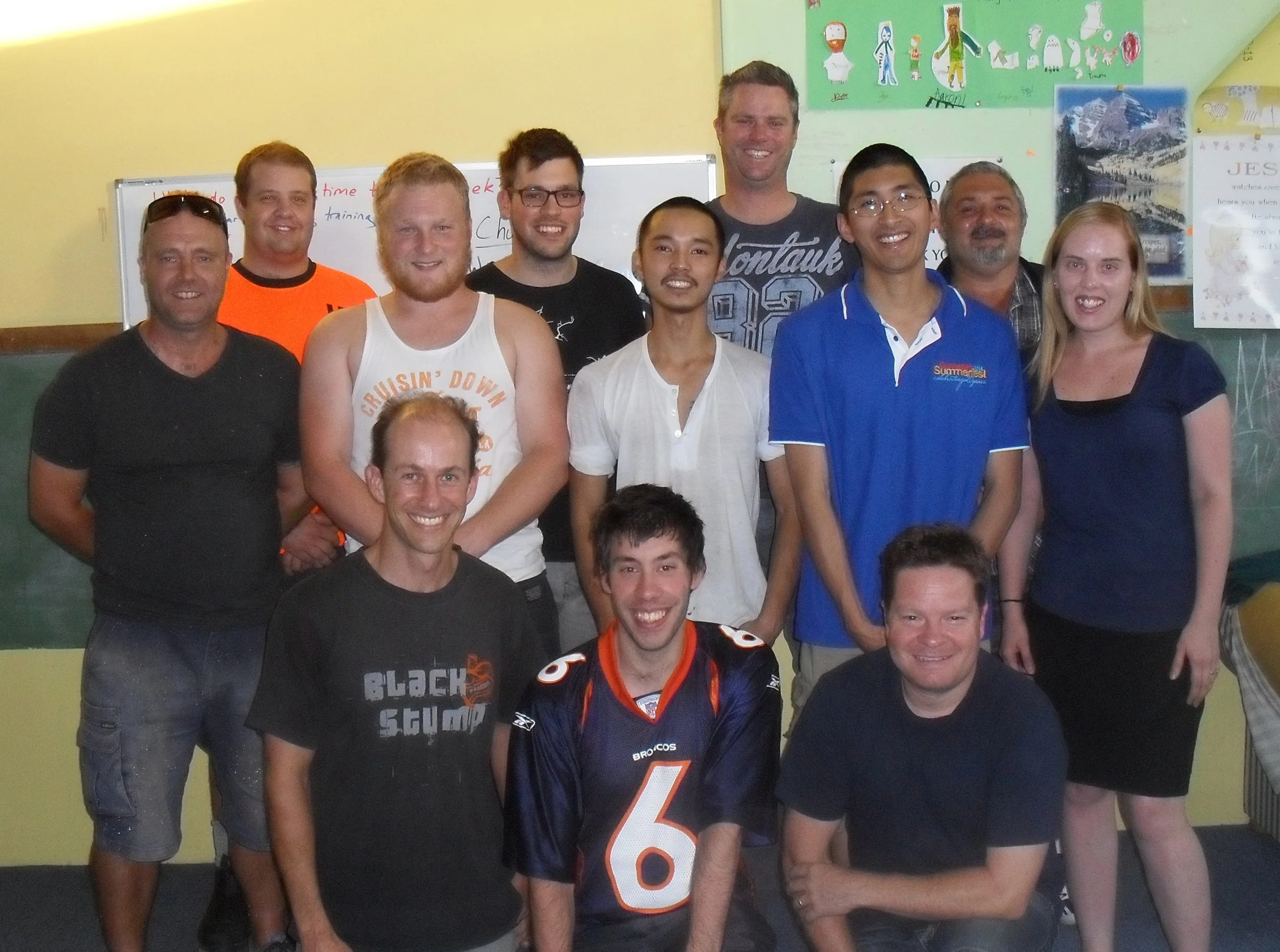 Andrew with eleven smiling students from a variety of cultural and educational backgrounds