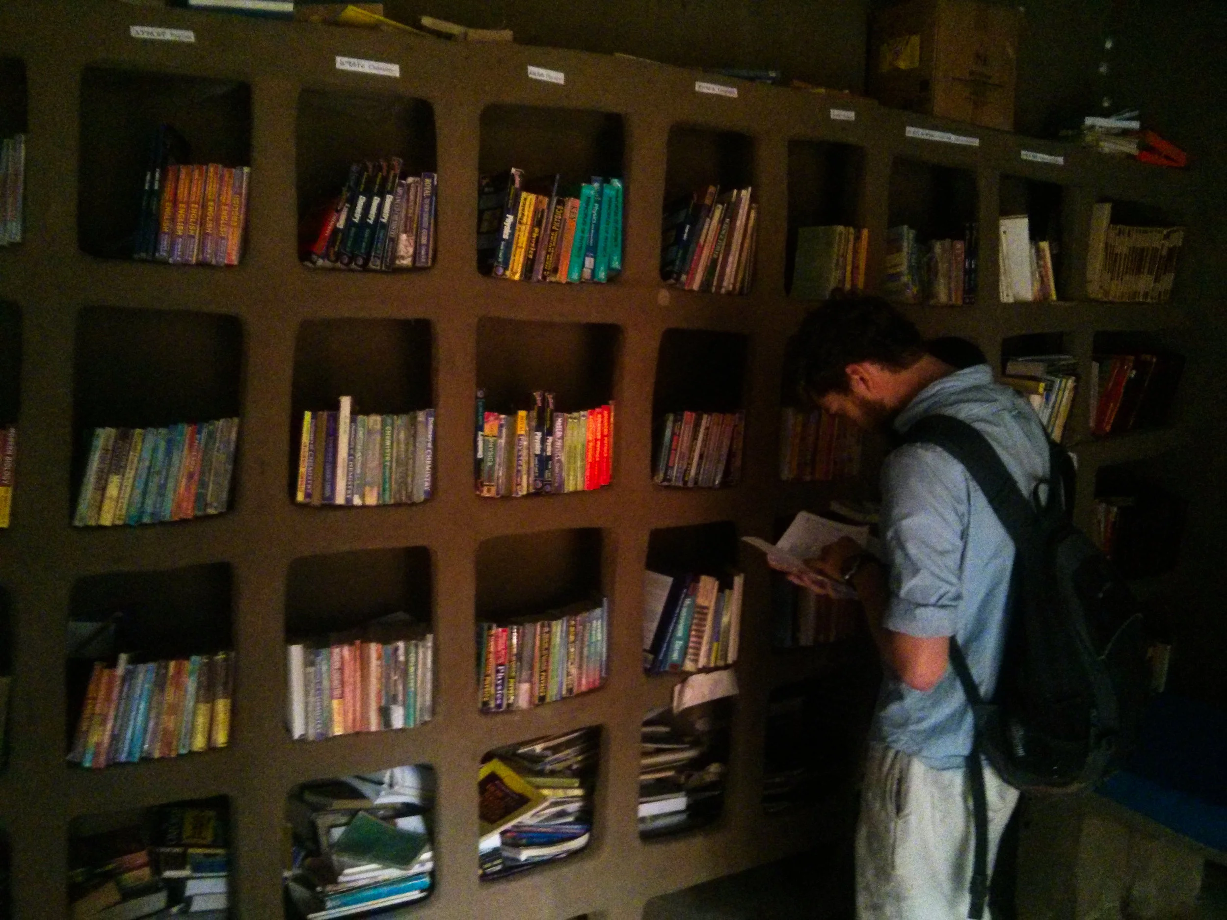 Perusing the mud shelves of the community library... (Photo Credit: Nick Colwill)