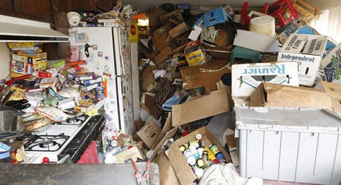 room with trash and boxes piles to the ceiling