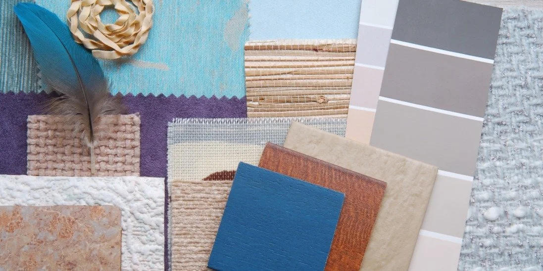 There are several tiles, all made of different materials, and a few color swatches on a wooden surface.