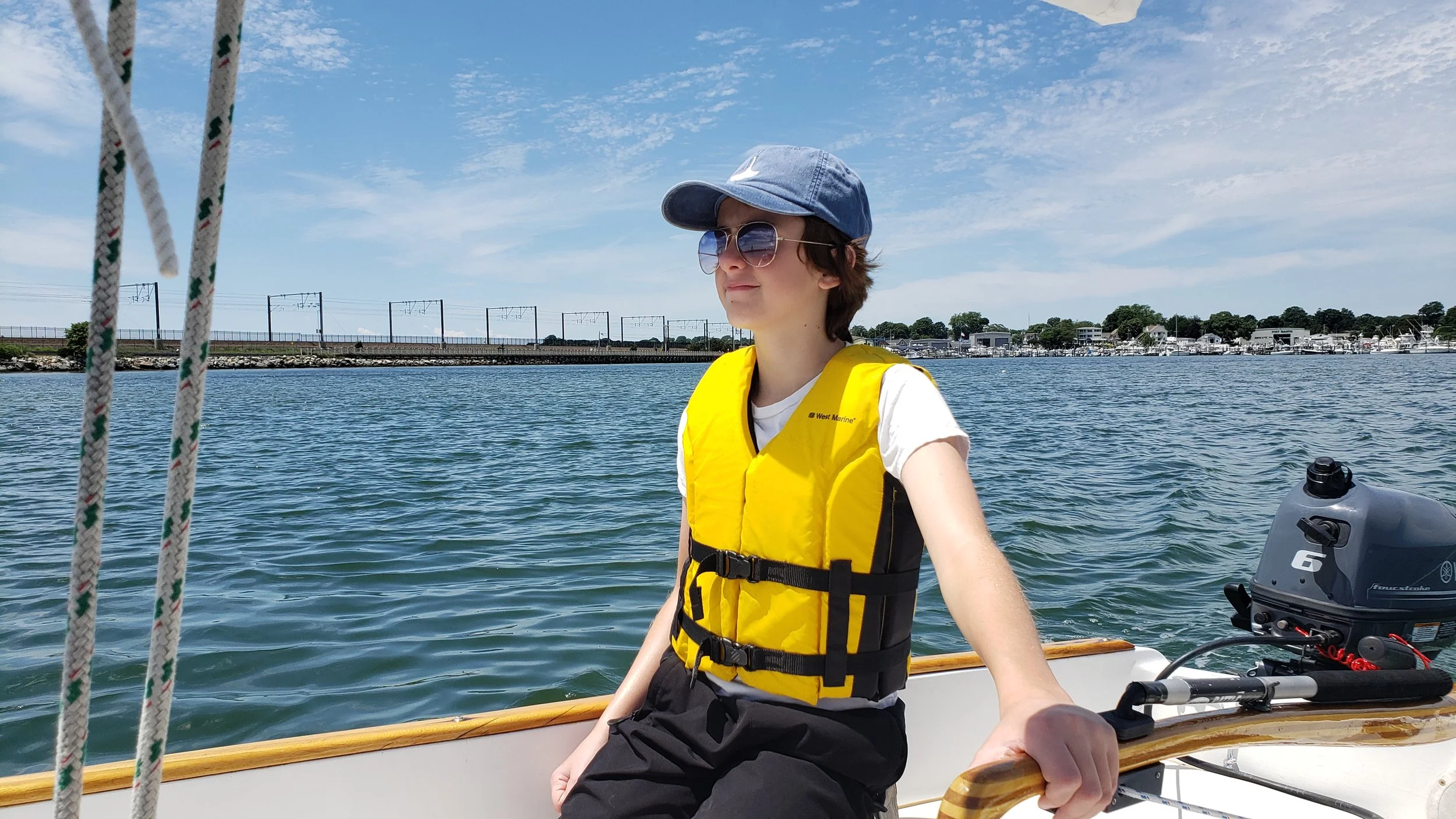 June 25th: I sailed with my son, Harry, to the annual WoodenBoat Show held at Mystic Seaport. Here he is motoring down the Niantic River channel.