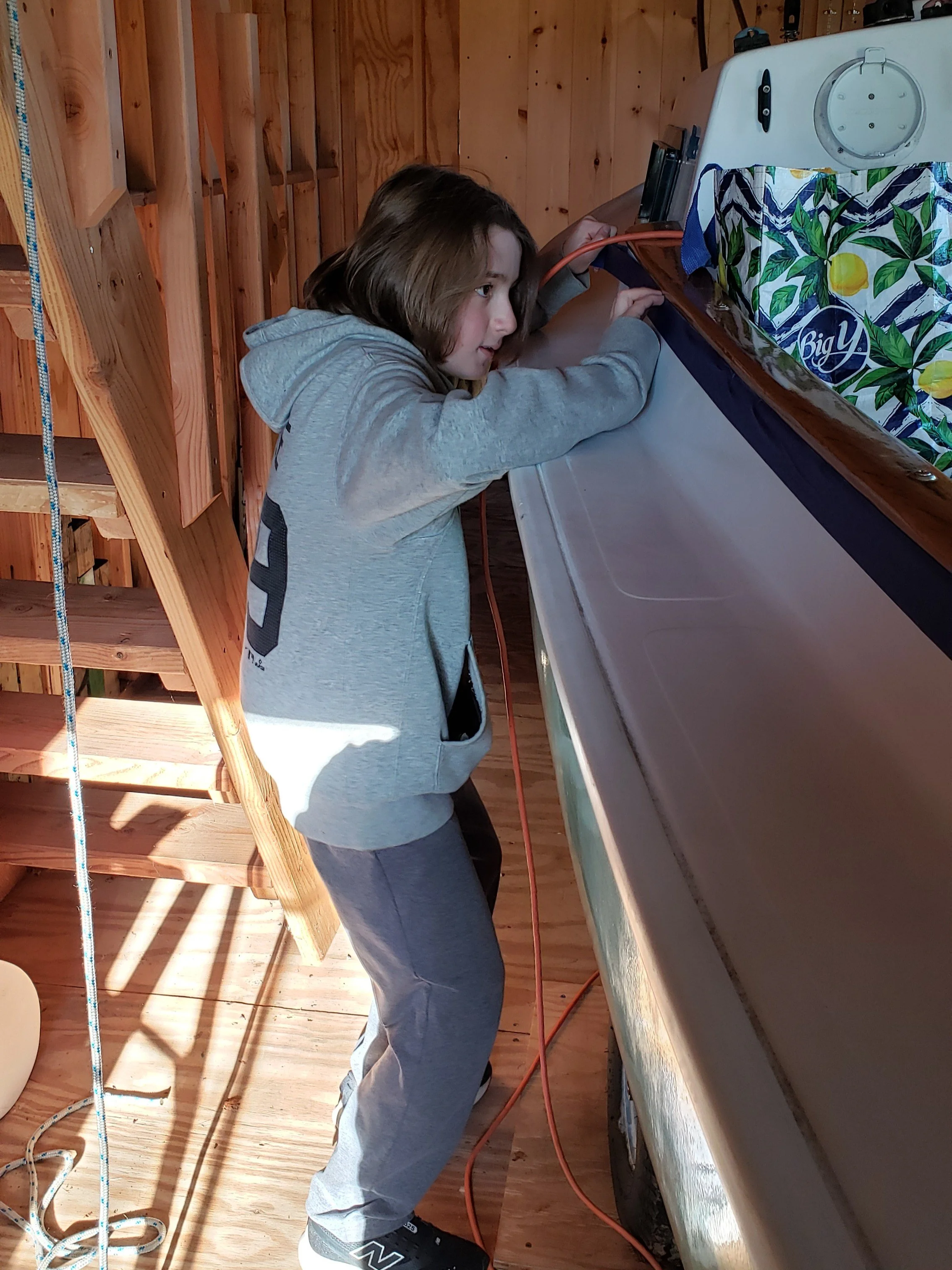 April 11th: The weather finally gets warm enough so that I can varnish all the wood. Harry helped tape off the coaming tops.