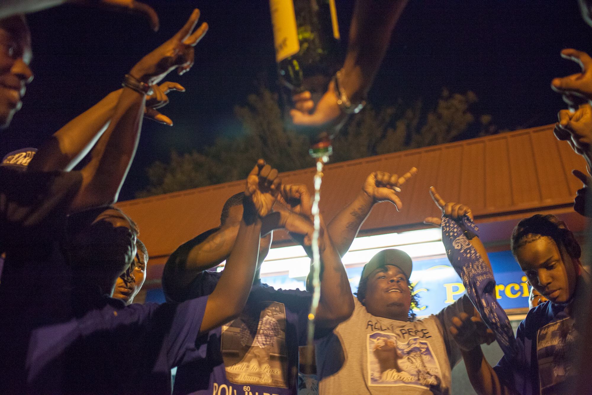  Young men who identify as Crips gather in a circle and spill liquor to mourn Maurice Streeter, who was shot and killed in April 2013. Neighborhood cliques and gangs offer young people a sense of purpose and family in neighborhoods torn apart by pove