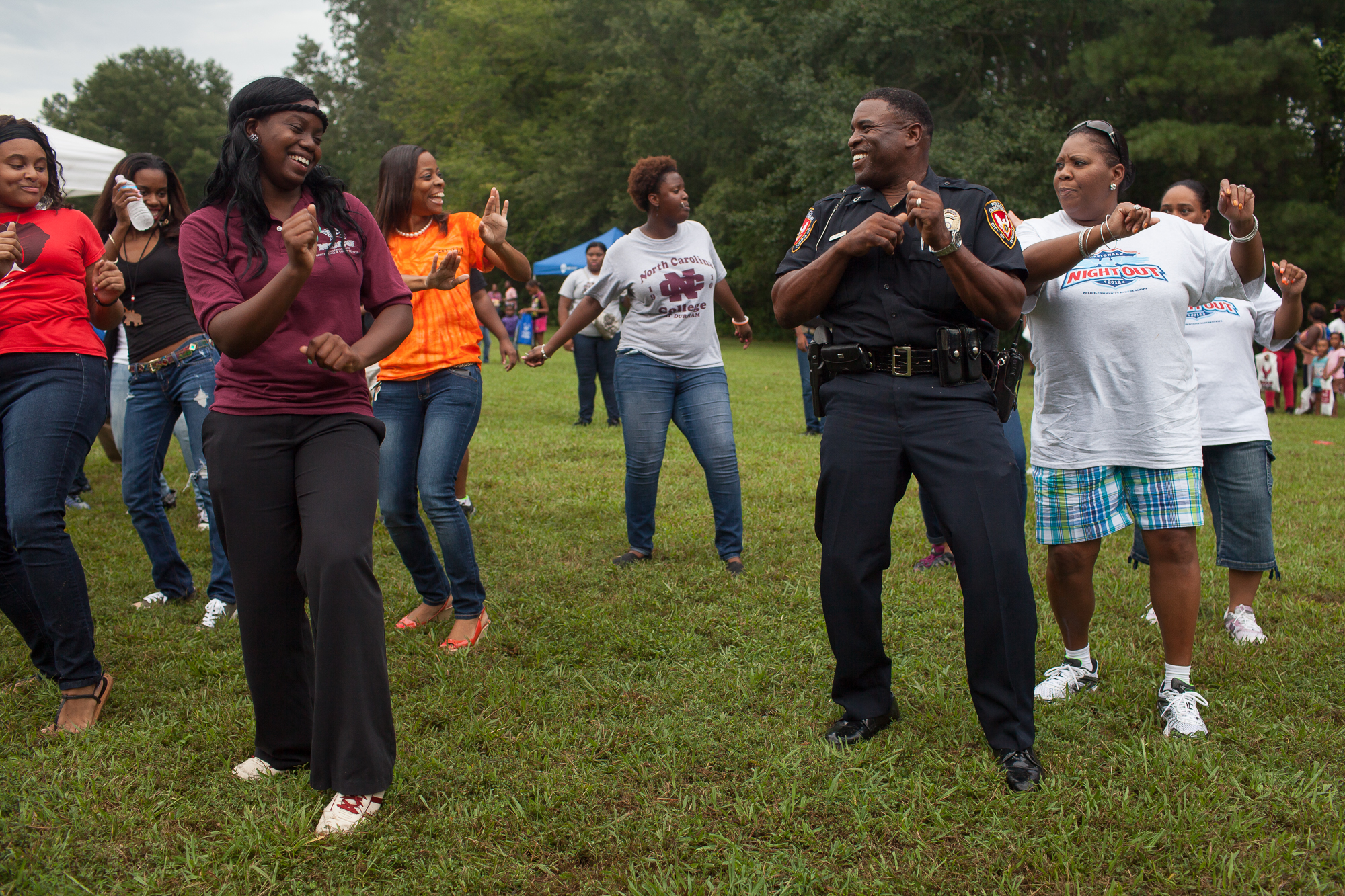  Durham Police officer R. Carson dances with members of North Carolina Central University’s step dance team during National Night Out near McDougald Terrace, a low-income public housing project where shootings have been frequent. National Night Out e