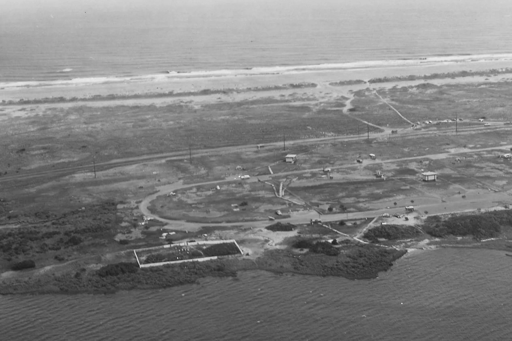 The Salvo Community Cemetery in 1970, with a complete fence and a shoreline with vegetation. Courtesy of National Park Service, Cape Hatteras National Seashore