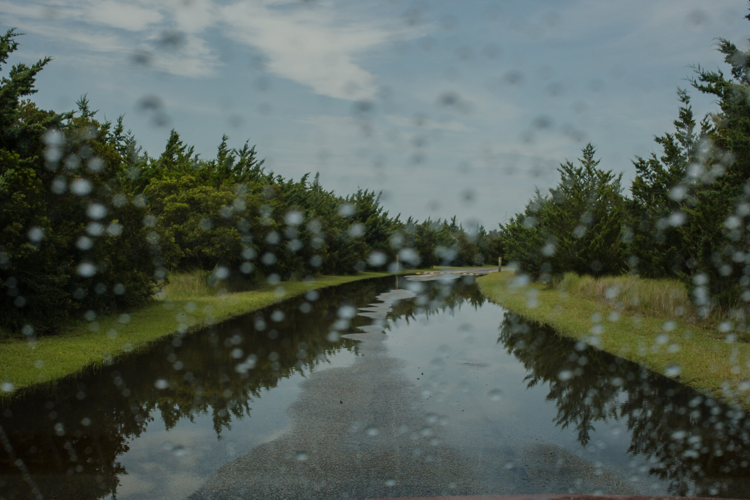  The entrance to the Salvo Day Use Area and Community Cemetery. The spongey land stays flooded even after a summer thunderstorm. Sunny day flooding driven by wind and small storms is increasingly common on the Outer Banks. Today, even a strong 40-mph