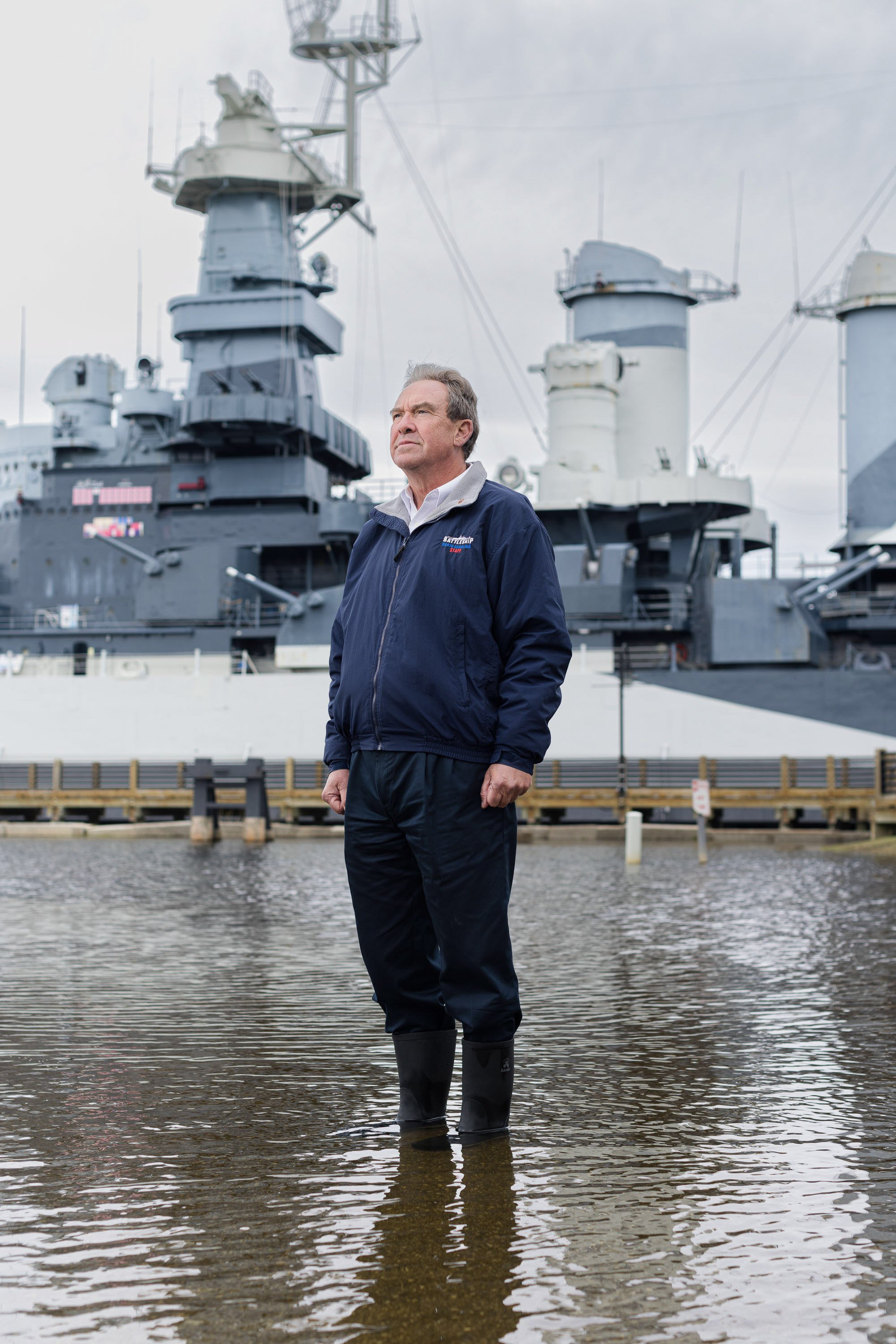  Captain Terry Bragg, executive director of Battleship North Carolina poses for a portrait in the flooded parking lot at the U.S.S. North Carolina Battleship National Historic Site. A high tide exacerbated by a king tide and sea level rise caused by 