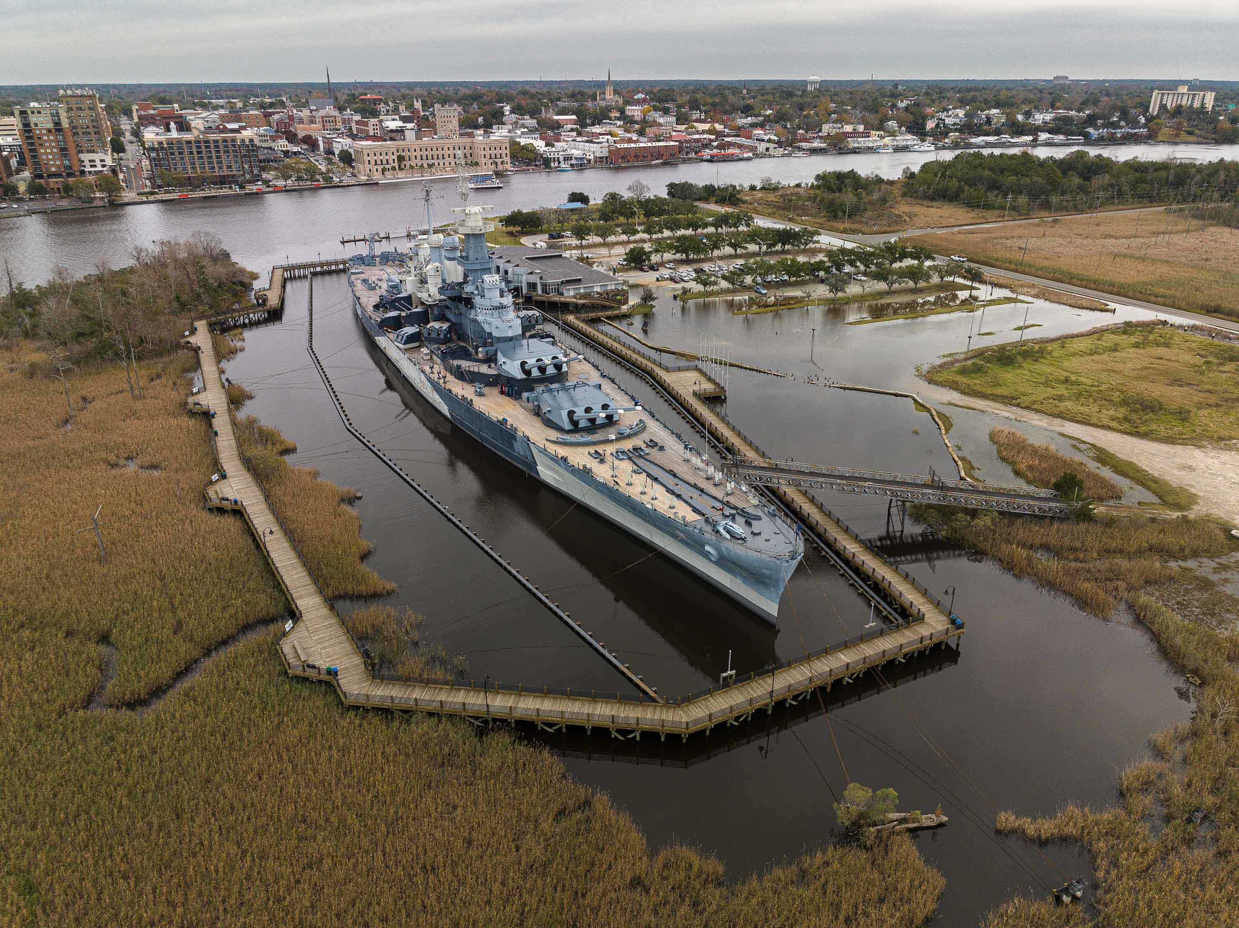  A drone view of the U.S.S. North Carolina Battleship National Historic Site, and its flooded parking lot at high tide. A high tide exacerbated by a king tide and sea level rise caused by human-induced climate change flooded the parking lot. For The 