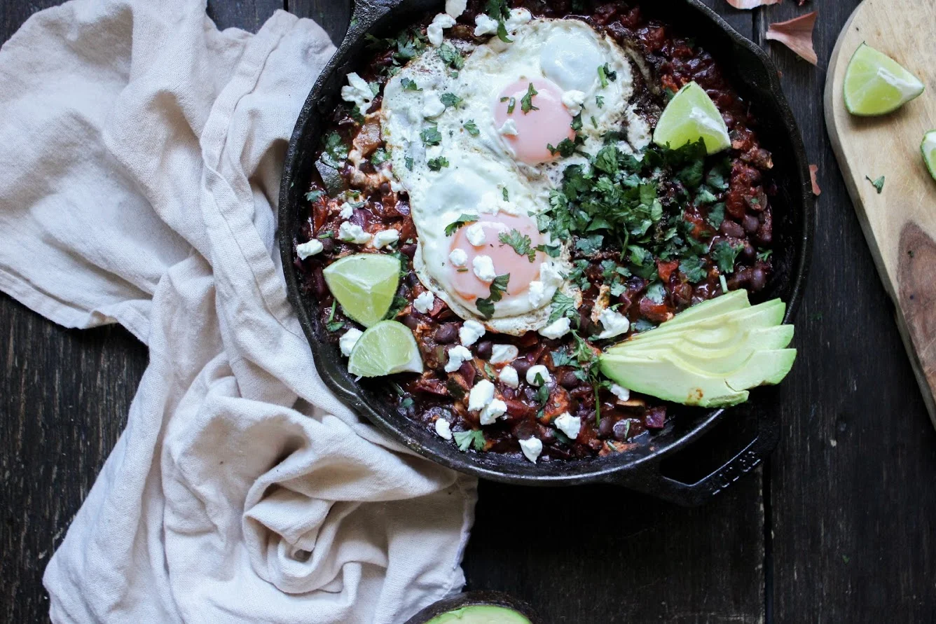 black bean chipotle heuvos rancheros + sunny side fried eggs & crispy potatoes