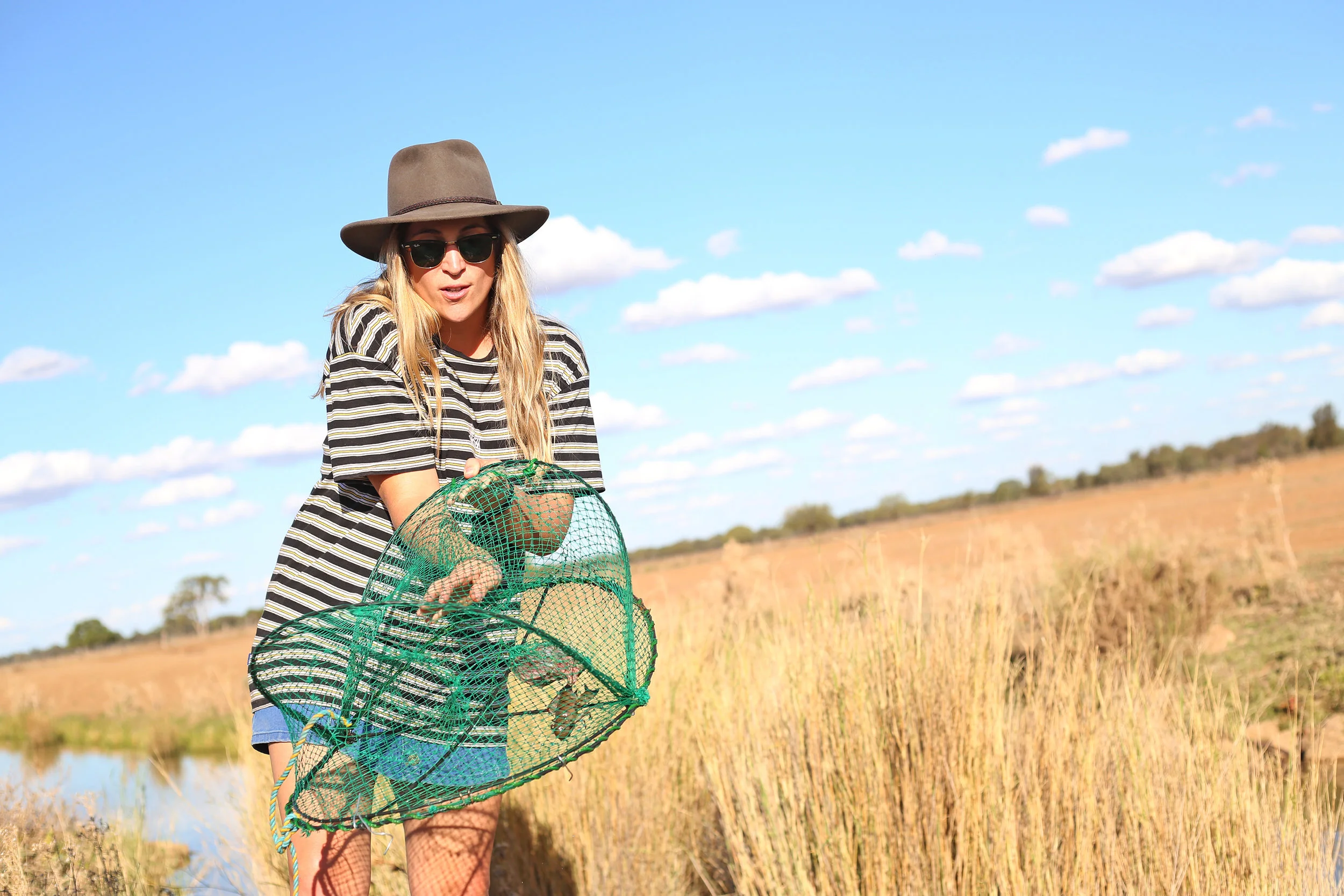 Bianca pulls a yabby out of a trap.
