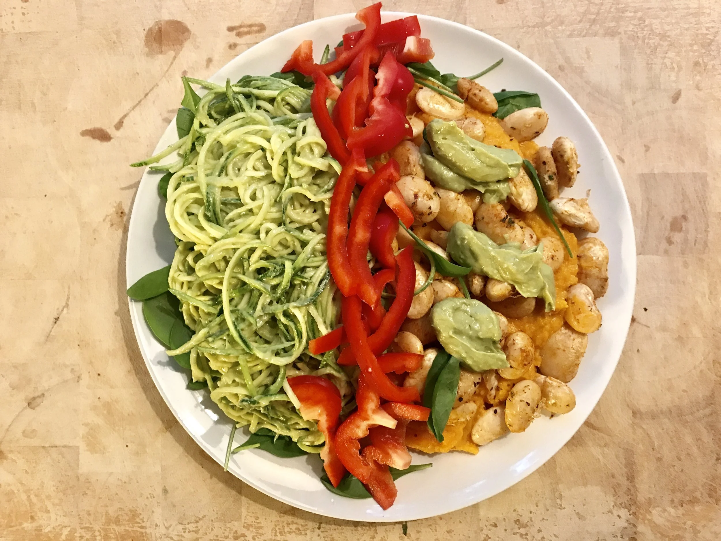 Kesäkurpitsapastaa (raakaa) avocadokastikkeella, bataattimuusia ja voipapuja.