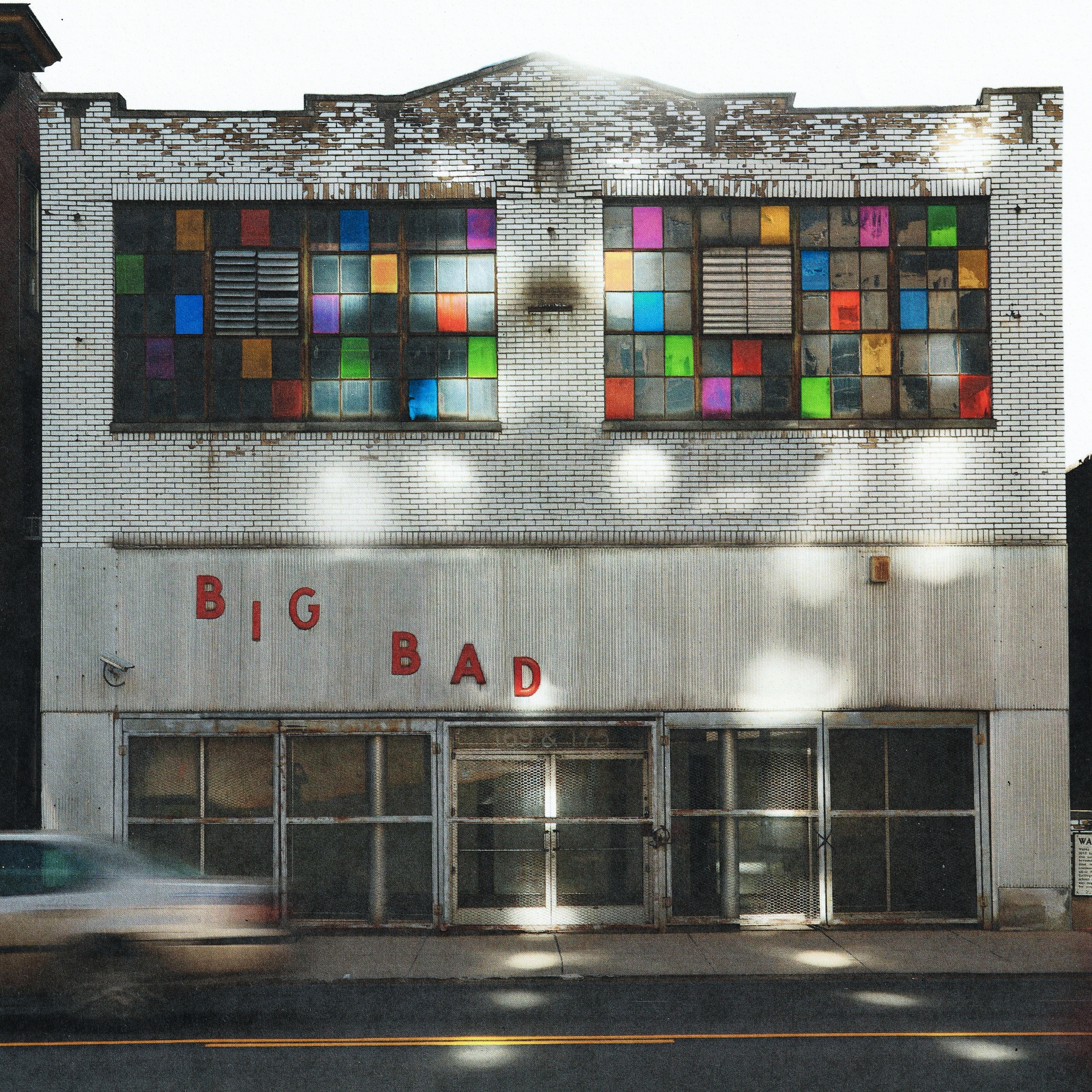 "Big Bad album cover art — vintage white brick storefront facade with colorful stained-glass style windows and red block-letter 'BIG BAD' signage"