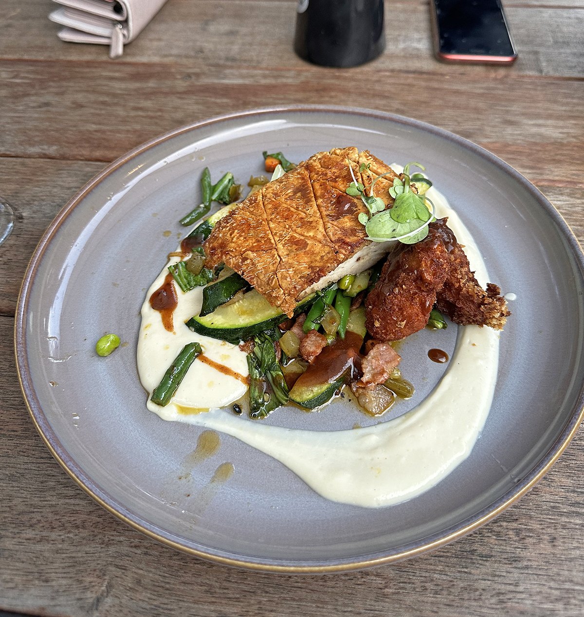 Crispy skinned pork belly with crumbed scallops, garlic butter cannellini beans, bok choy, fennel &amp; orange sofrito &amp; cauliflower puree