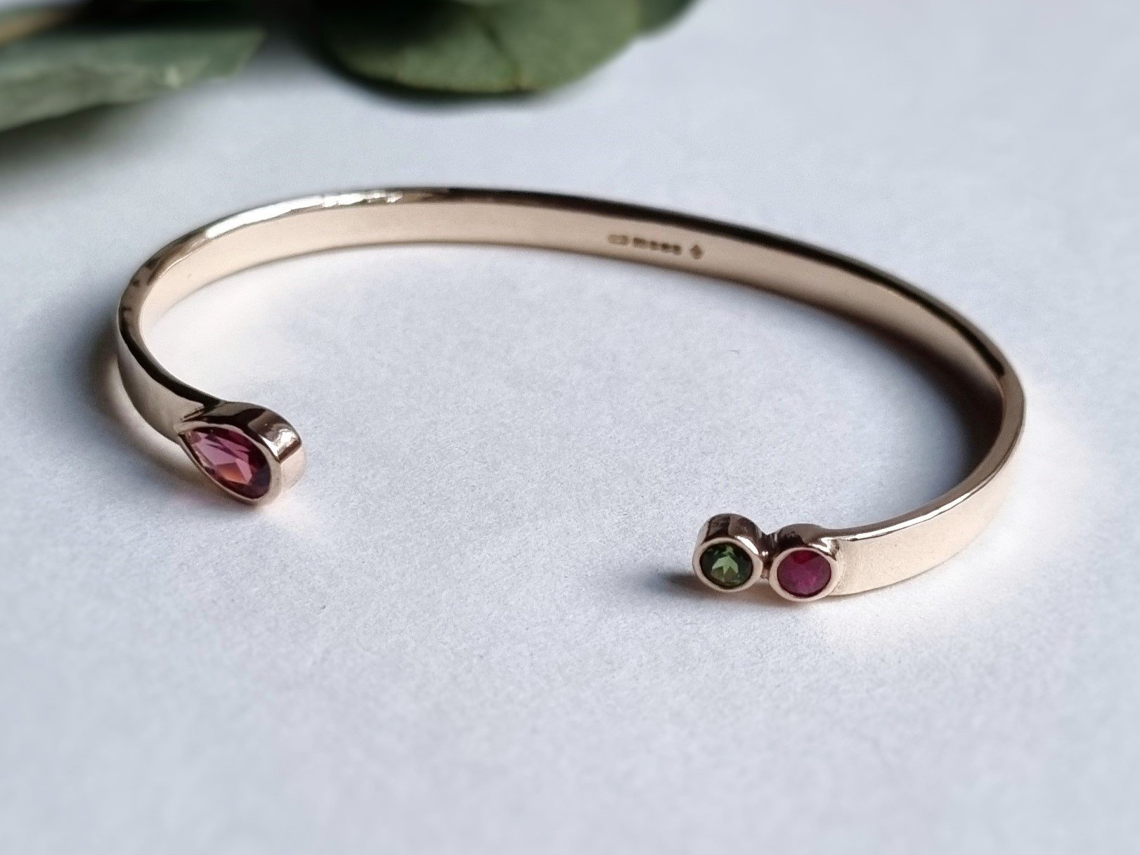 9ct hammered yellow gold bangle with rubies tourmalines.jpeg