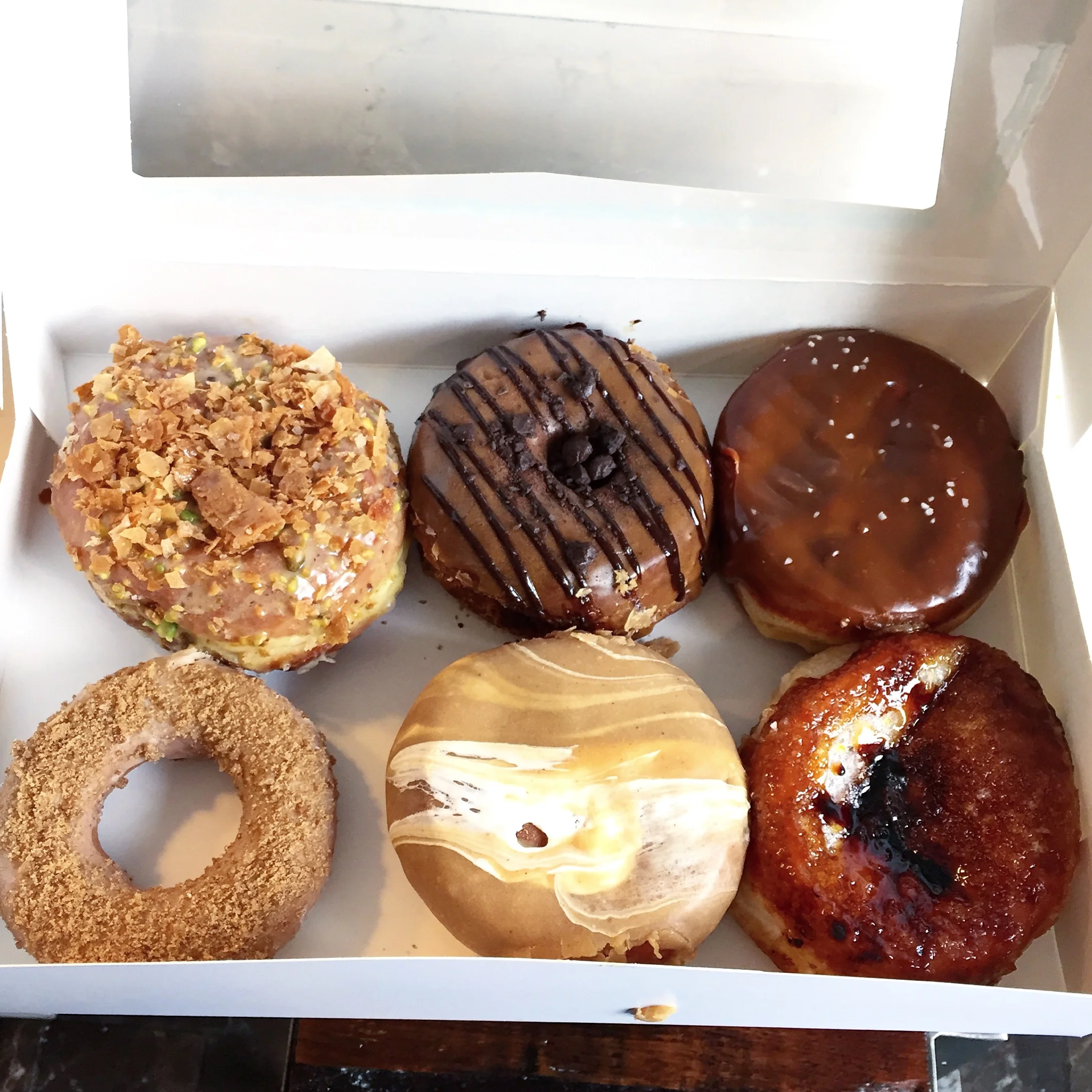Left to right, top to bottom: Baklava, Dark Chocolate Ganache, Salted Dulce de Leche, Brown Butter, Fluffernutter, Creme Brulee from District Doughnuts