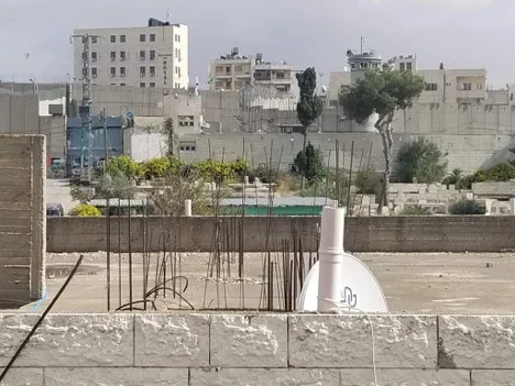 The view from a rooftop in Aida Refugee Camp. The blue gate on the left can be pulled up so that Israeli forces can roll tanks into the camp at any time. (Photo by Charlie Finn)