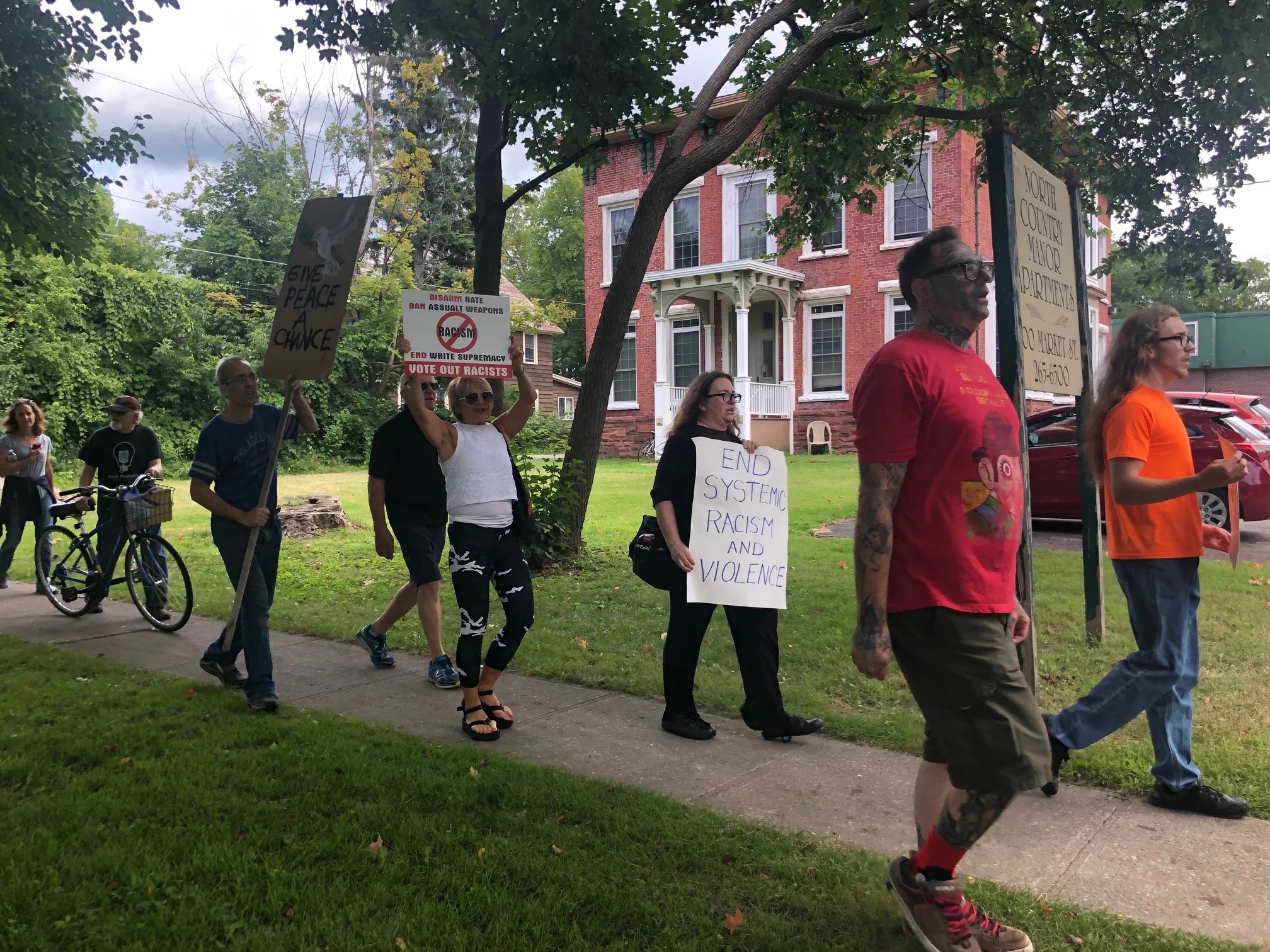 Demonstrators in Potsdam's "March against Racism" pass 100 Market St., the former home of Garrett Phillips, whose 2011 murder—and the subsequent trial of Oral "Nick" Hillary as the prime suspect—intensified racial tensions in the majority-white community.