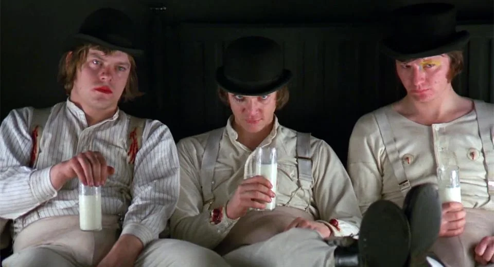 (From left) , Warren Clarke as Dim, Malcolm McDowell as Alex, and James Marcus as Georgie Boy (drinking milk!! =O) in Stanley Kubrick’s famous adaptation of Anthony Burgess’ novel A Clockwork Orange; Alex was not the only antihero in that story