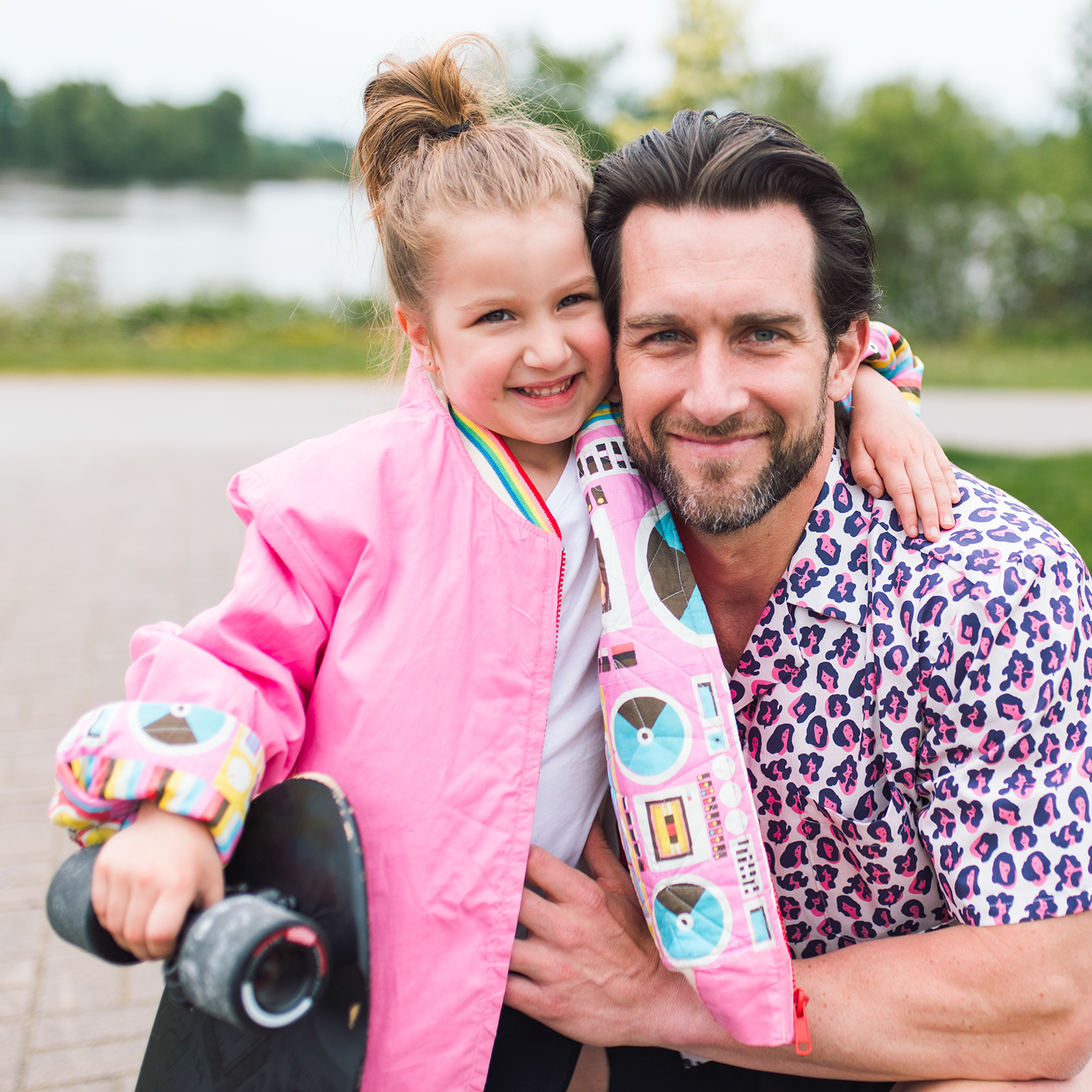 girl with skate board hugging her dad.png