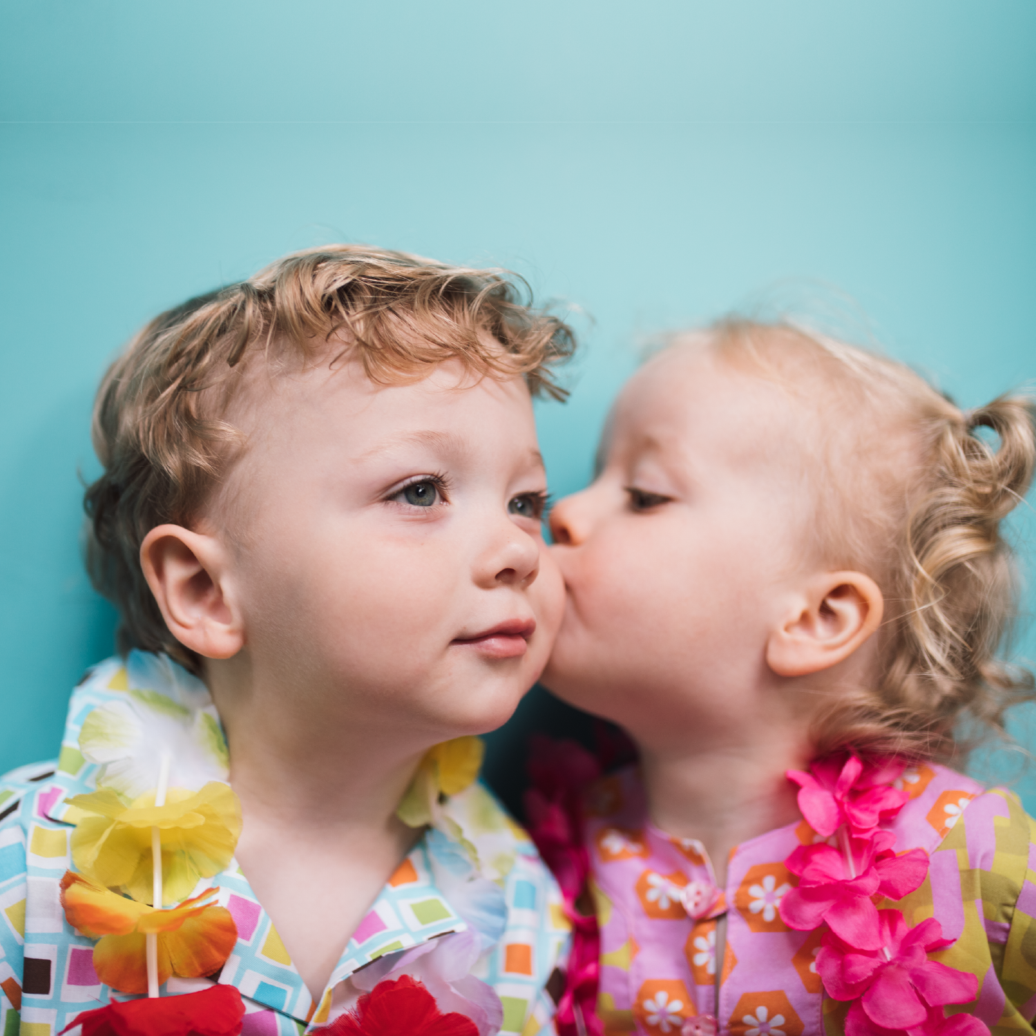 little girl kissing little boys cheek, wearing lysa flower clothing.png