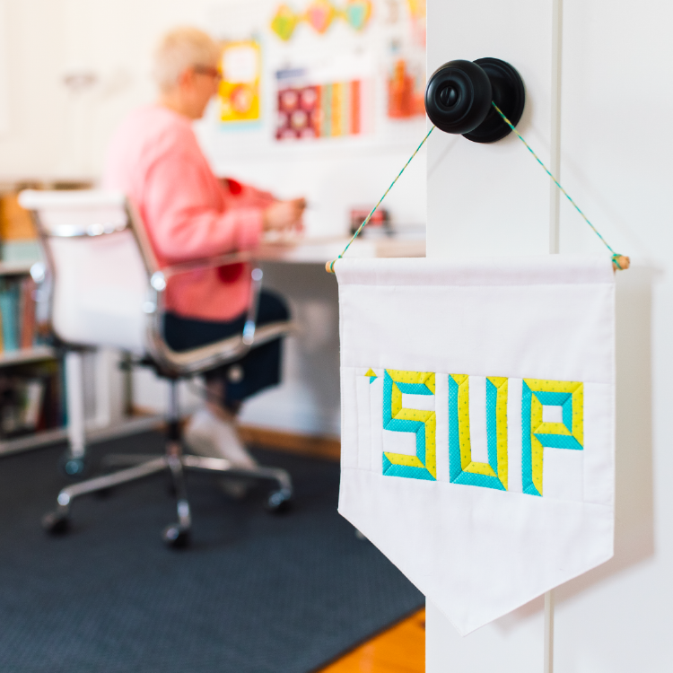 lysa flower working in her studio with the door open. a sign on the door says sup.png