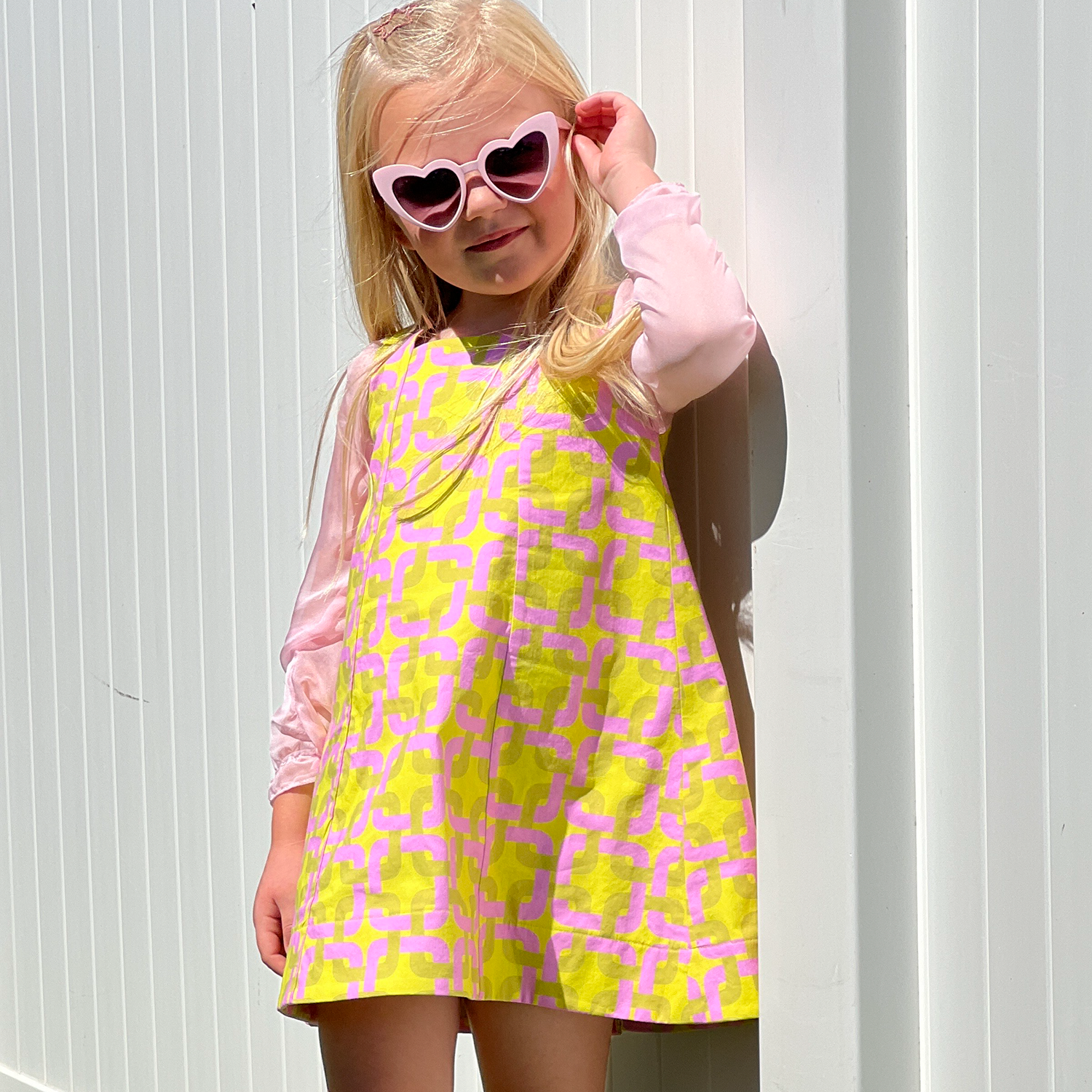 girl 60's looking dress wearing heart sunglasses.png