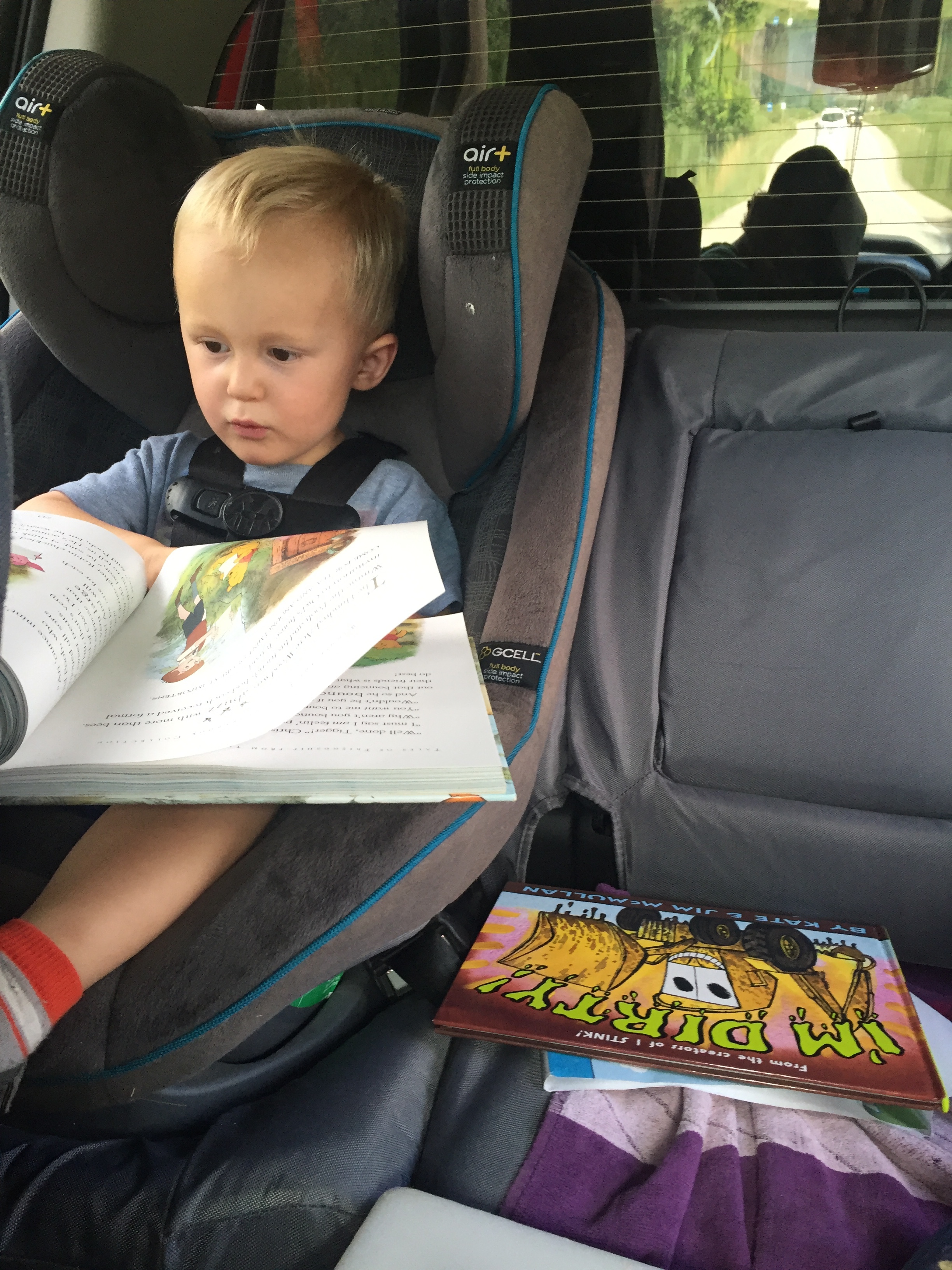 It is a glorious thing when your toddler begins to "read" to himself. Happy, self-entertained traveler! Score!