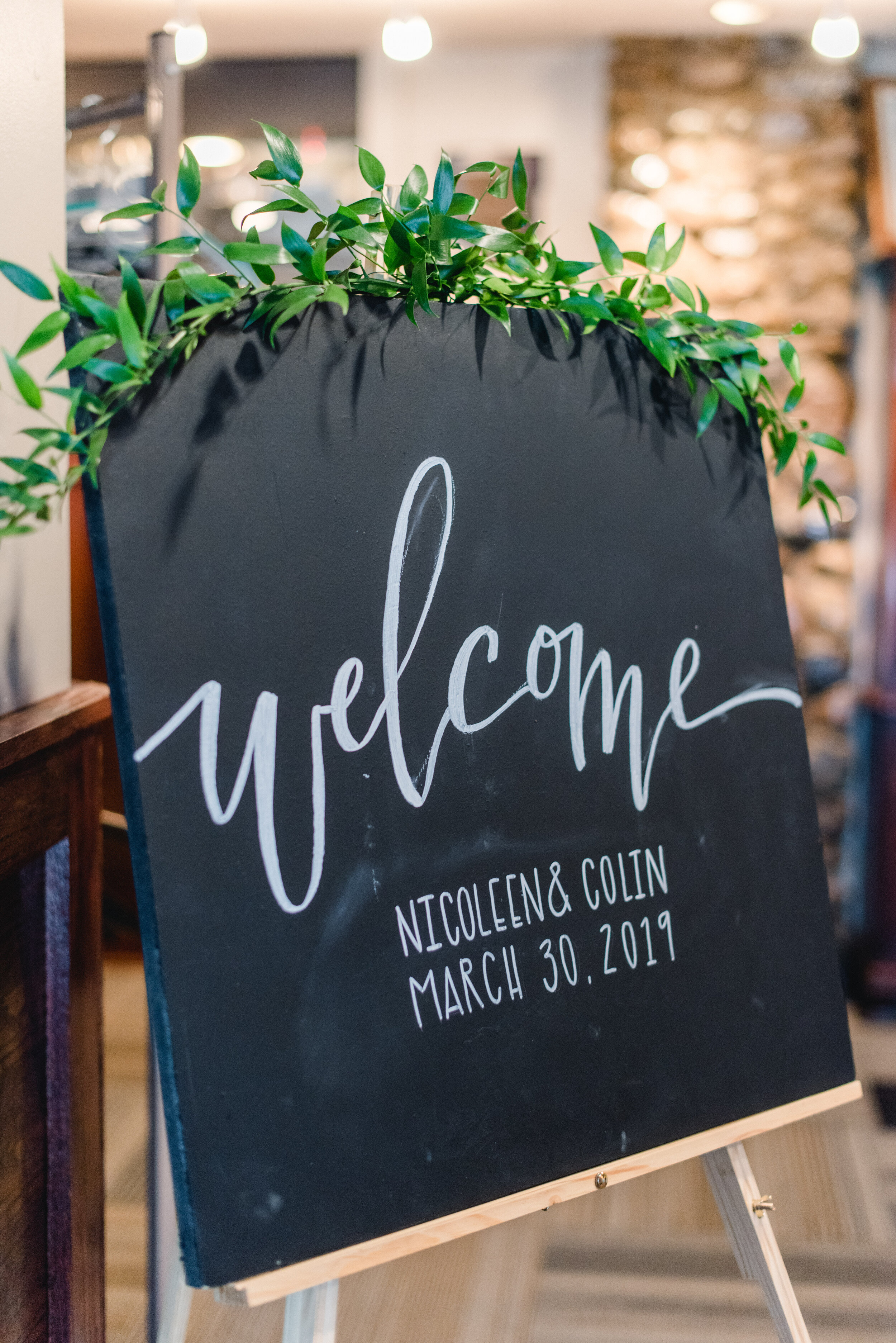 welcome sign with greenery ruscus.jpg
