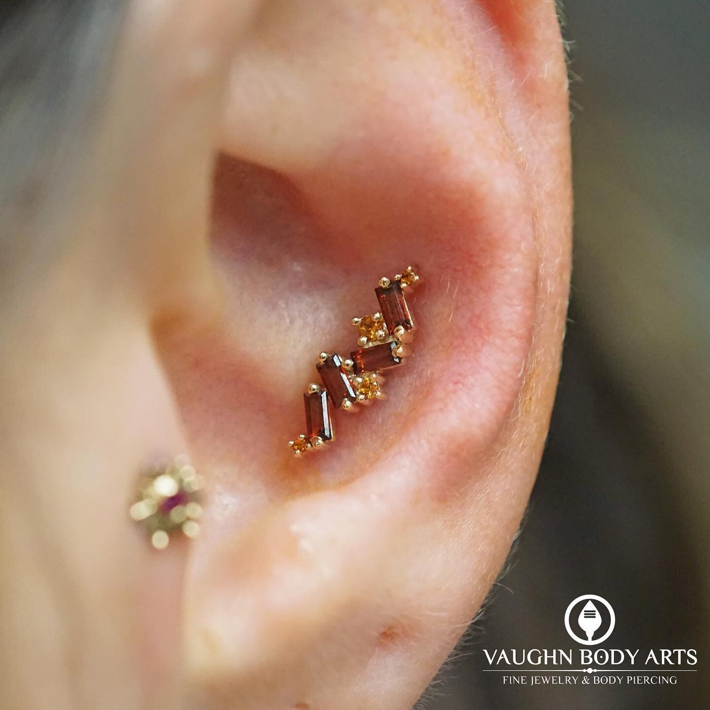 This lovely ear belongs to our wonderful client Nicole. 

She got a new conch piercing from Vaughn and chose this absolutely stunning &ldquo;Genesis&rdquo; from BVLA. Solid Yellow Gold with Genuine Garnets and Citrine. 

For her healed tragus, she ha