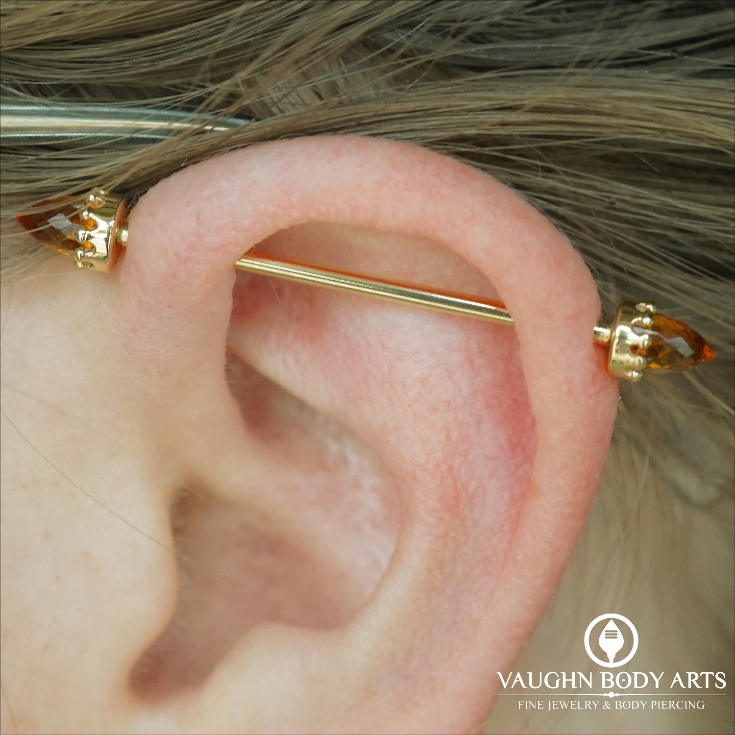 Here is a lovely industrial piercing we did for Hannah just over nine years ago. 

She recently stopped in and treated herself to this stunning new setup from BVLA. 

A solid Yellow Gold barbell with bullet-cut genuine Citrine set in Yellow Gold Crow