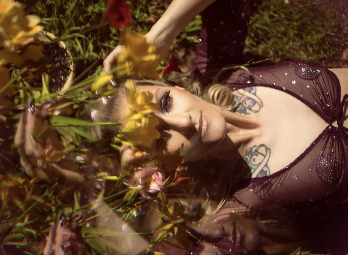 glamorous portrait of a blonde model's makeup with purple eyeshadow in a garden in Santa Cruz done by santa cruz makeup artist photo by gina barbara photography