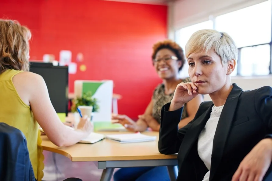 Confident female designer sitting at her desk for a brainstorming in red creative office space.jpeg