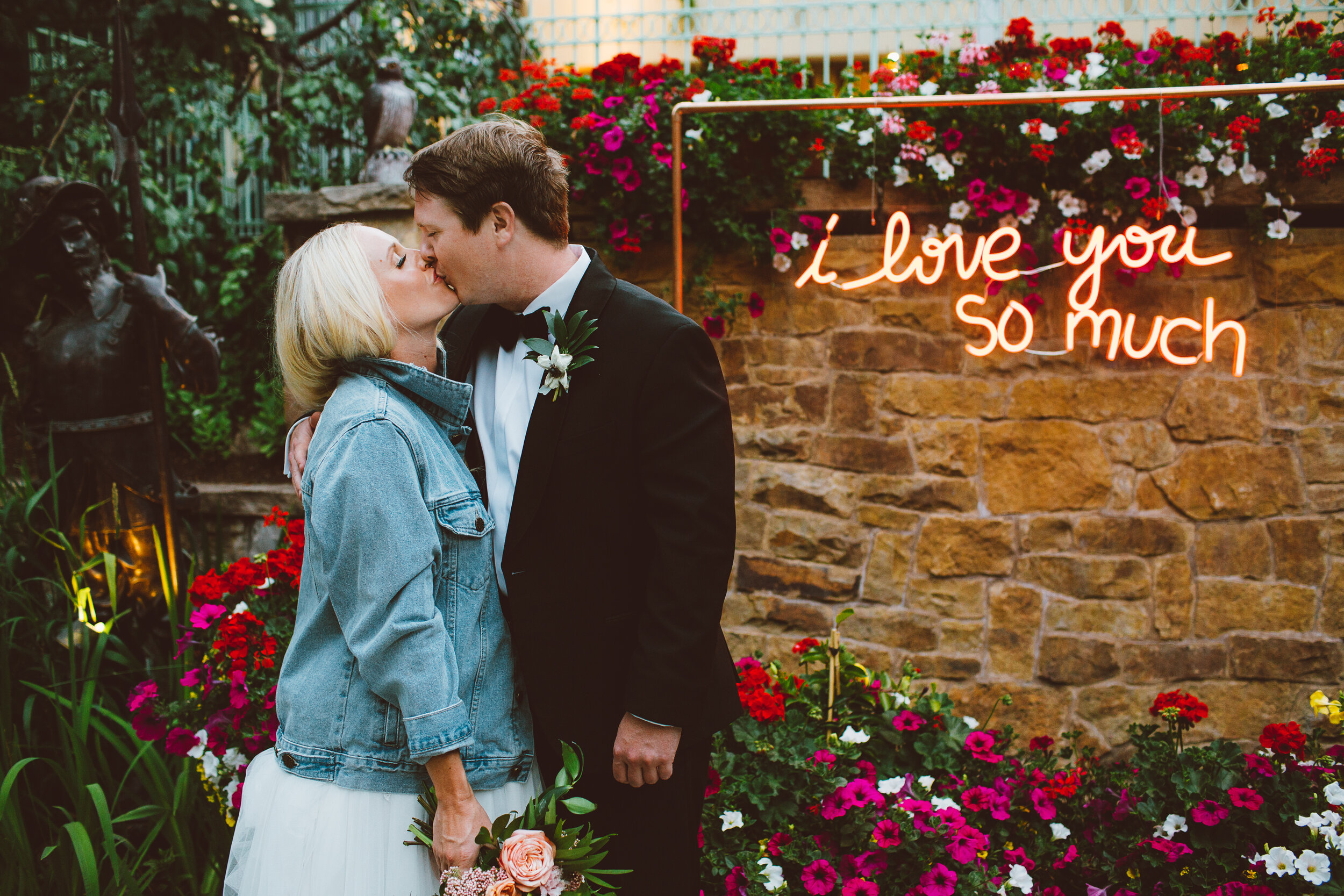 Bride and groom kissing with neon sign at Vail Colorado wedding