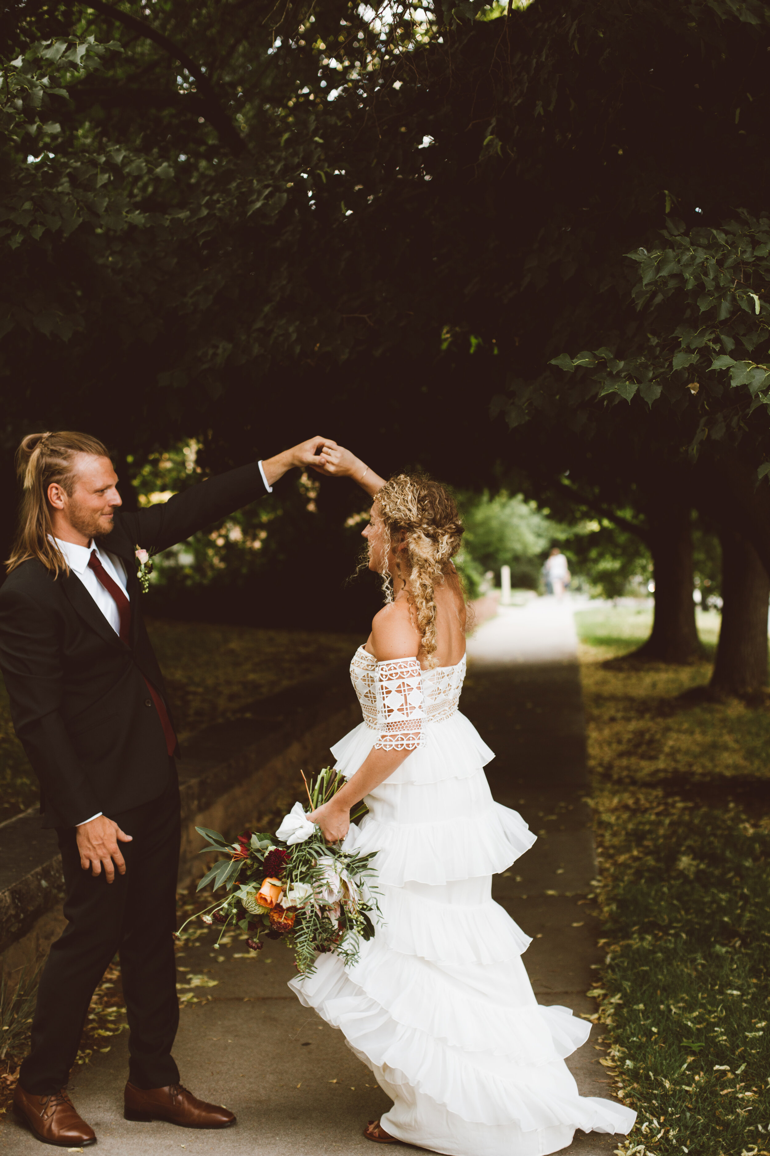 Groom twirling bride in boho wedding dress