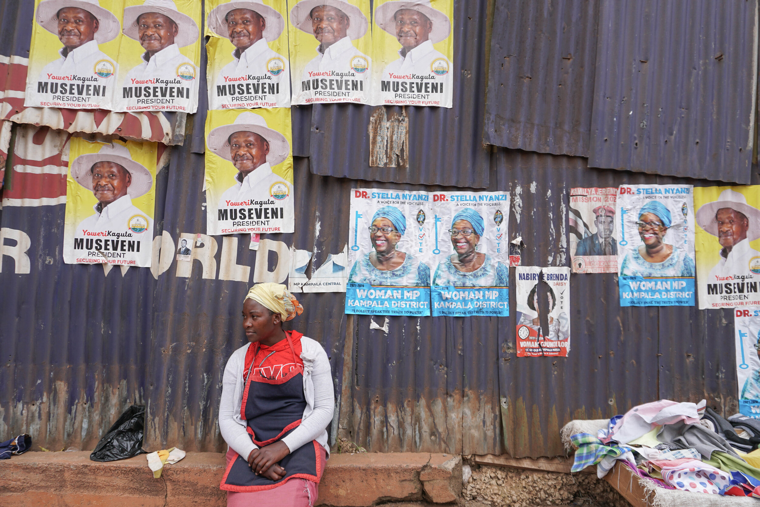 Street seller on Namirembe Road in central Kampala, in front of posters of Stella Nyanzi and President Yoweri Museveni.jpg