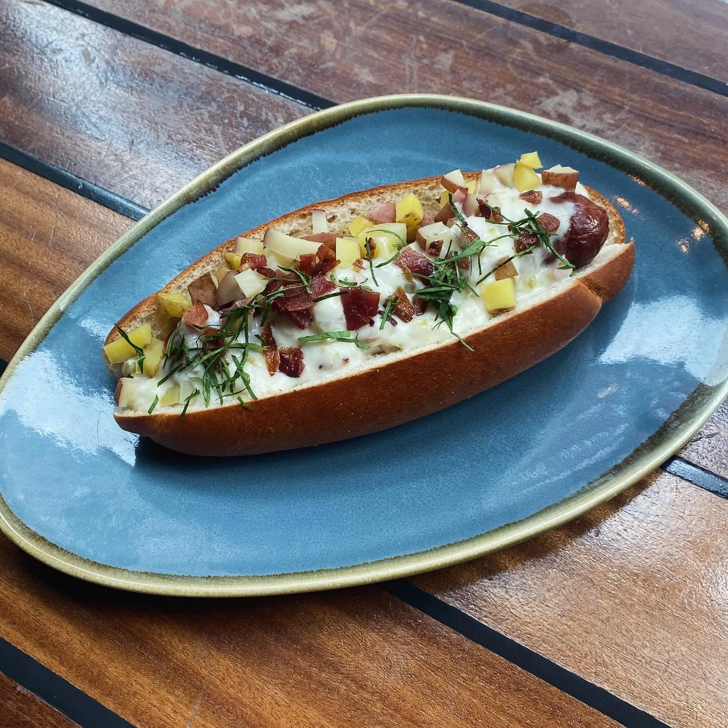 This #weinerwednesday is a touchdown! Inspired by our love for the New England Patriots, this dawg features a NE style chowder topping &mdash; bacon, potatoes, and a luxurious cream sauce. From the mind of @kathrynbritten, come cradle this all-beef p