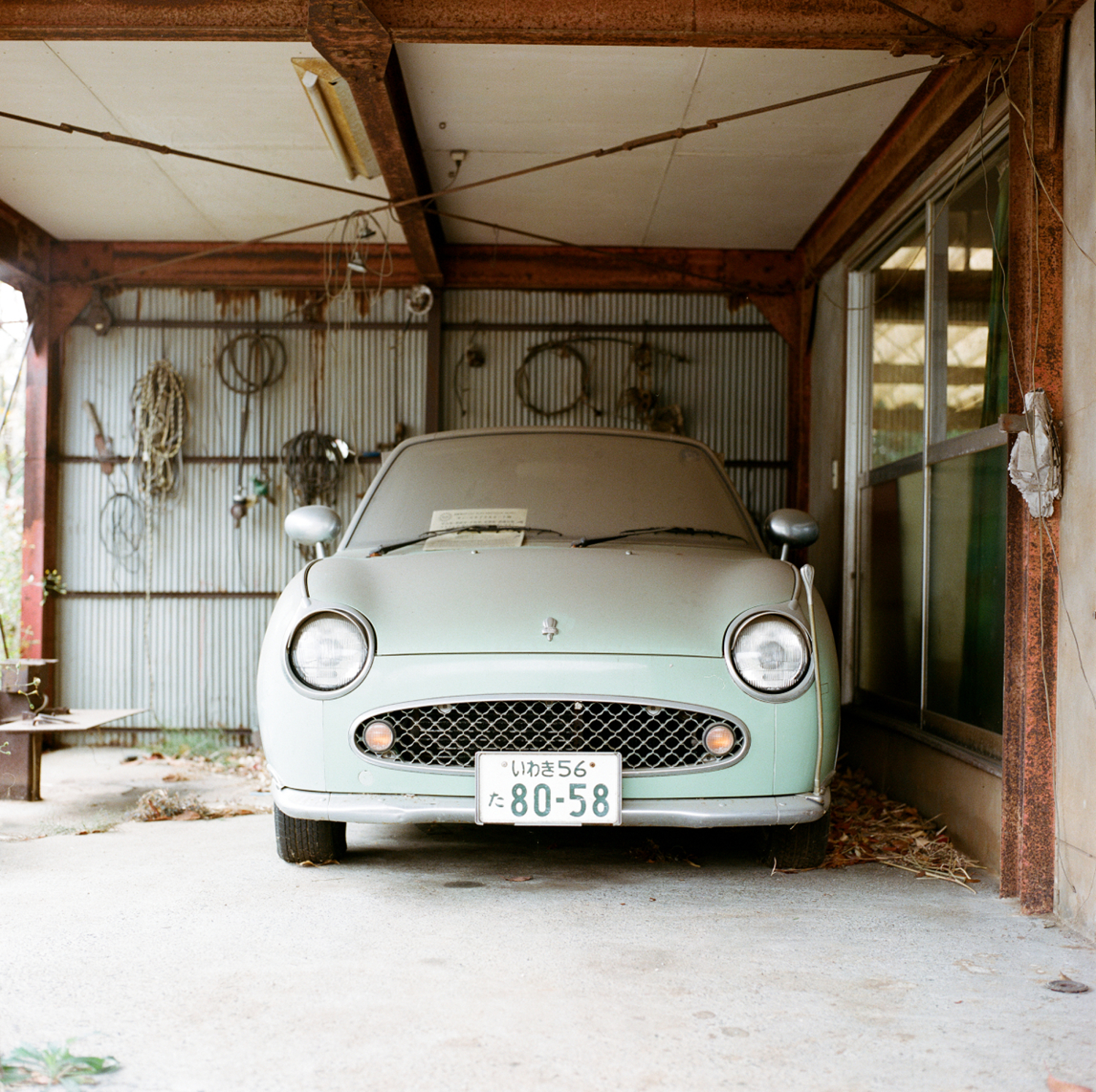  A Nissan Figaro (vintage car, build at 20000 ex. in the late 1980s) gathers dust for over four years and awaits the return of its owner. 