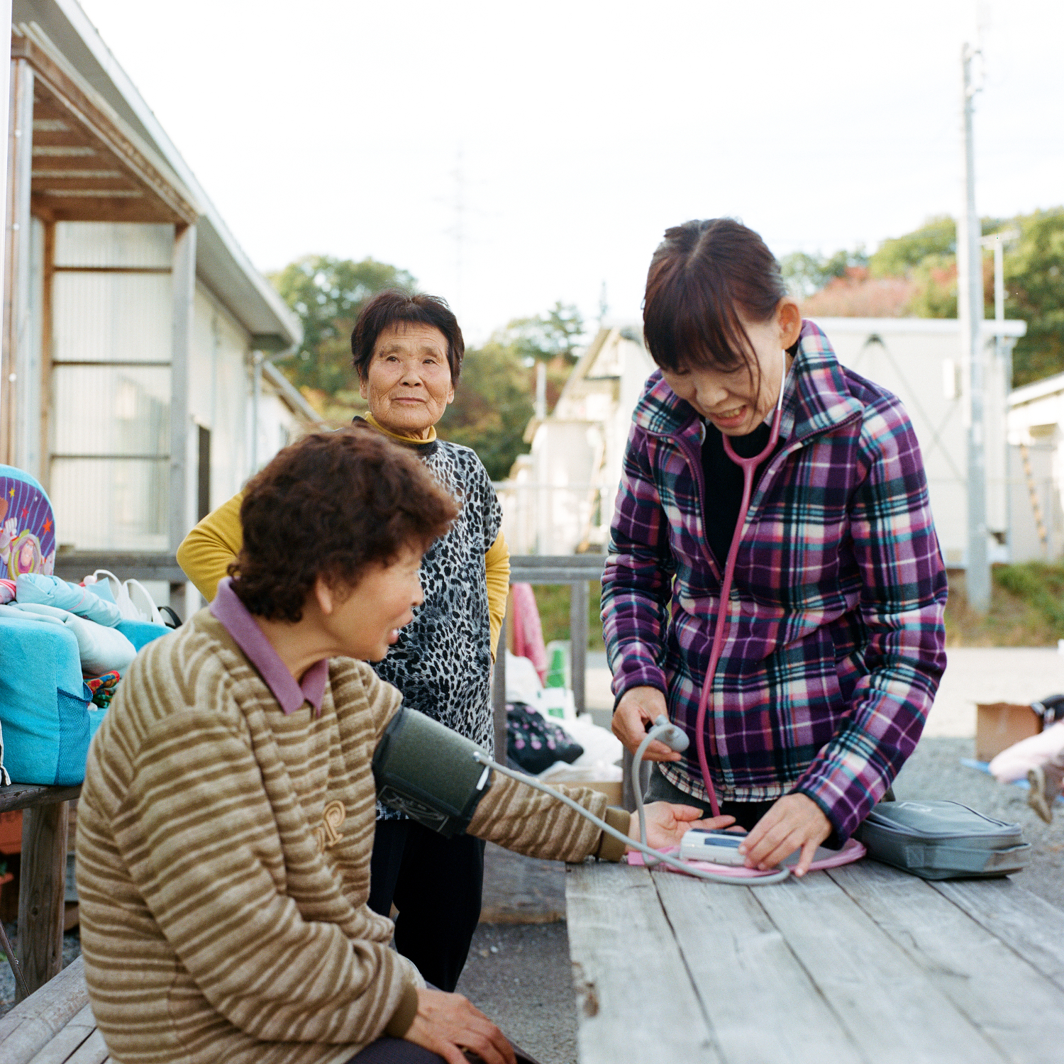 A volunteer nurse takes the opportunity to check up on some of the elderly people present.