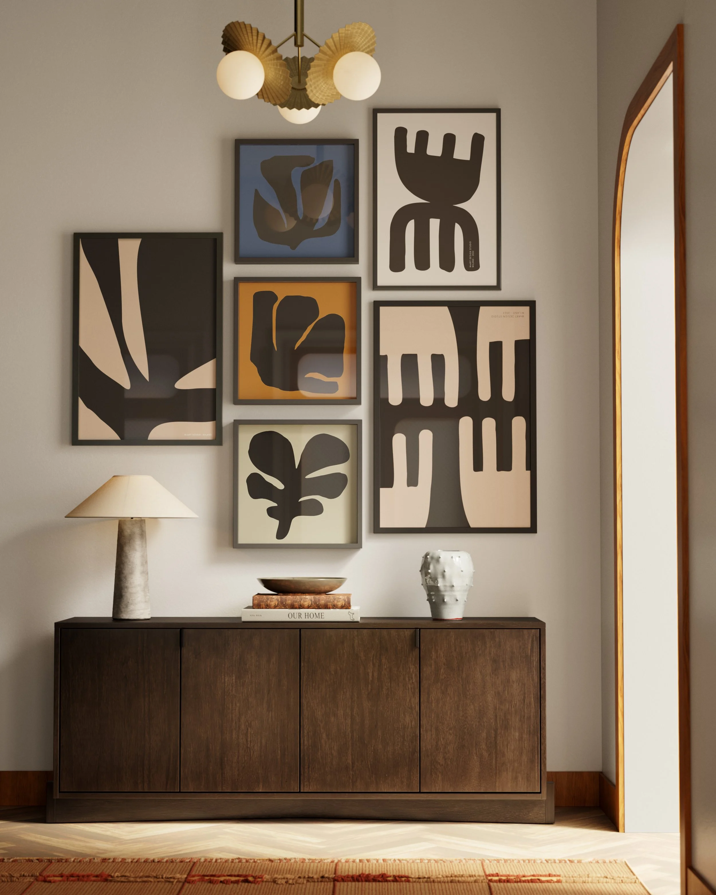 Wooden sideboard with table lamp, decorative bowls, and a white vase, against a wall with a gallery of abstract art in frames and a ceiling light fixture.